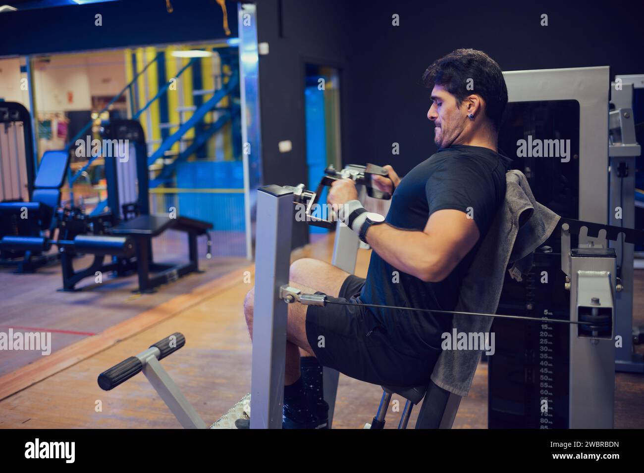 Homme concentré faisant des exercices de force dans une salle de gym Banque D'Images