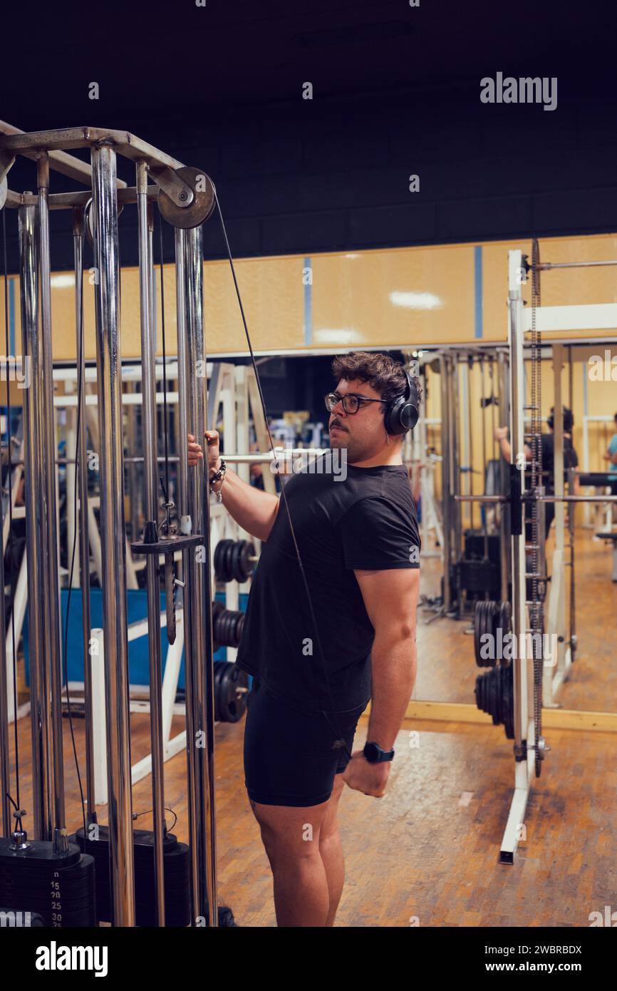Une personne est intensément concentrée sur soulever des poids à la salle de gym Banque D'Images