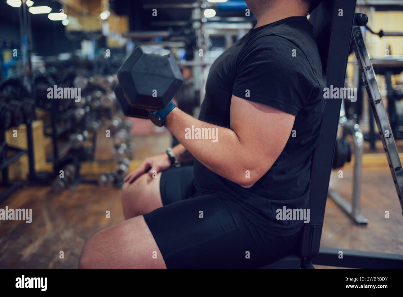 Gros plan d'un homme concentré faisant des exercices de force dans une salle de gym Banque D'Images