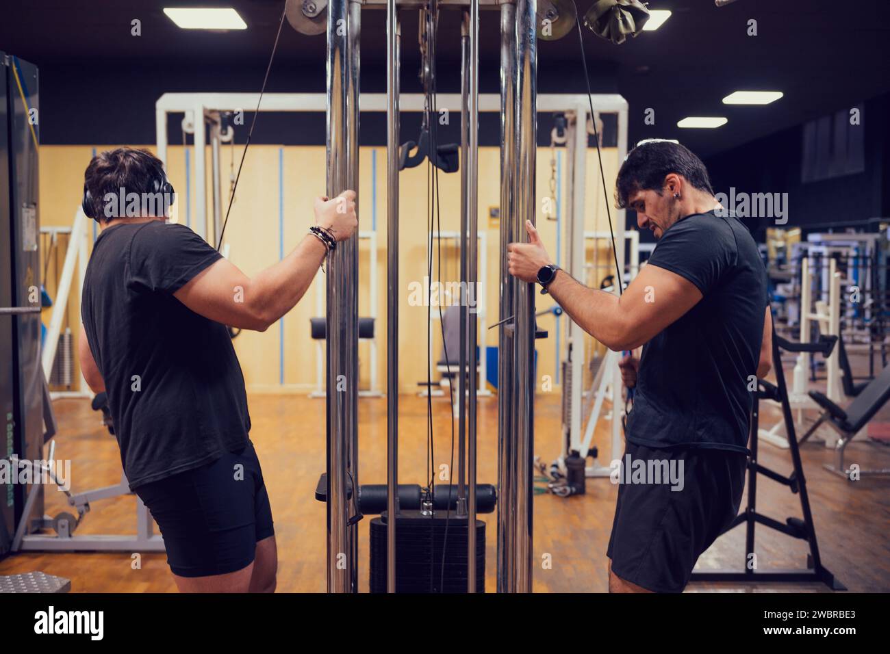 Deux hommes sont intensément concentrés sur soulever des poids à la salle de gym Banque D'Images
