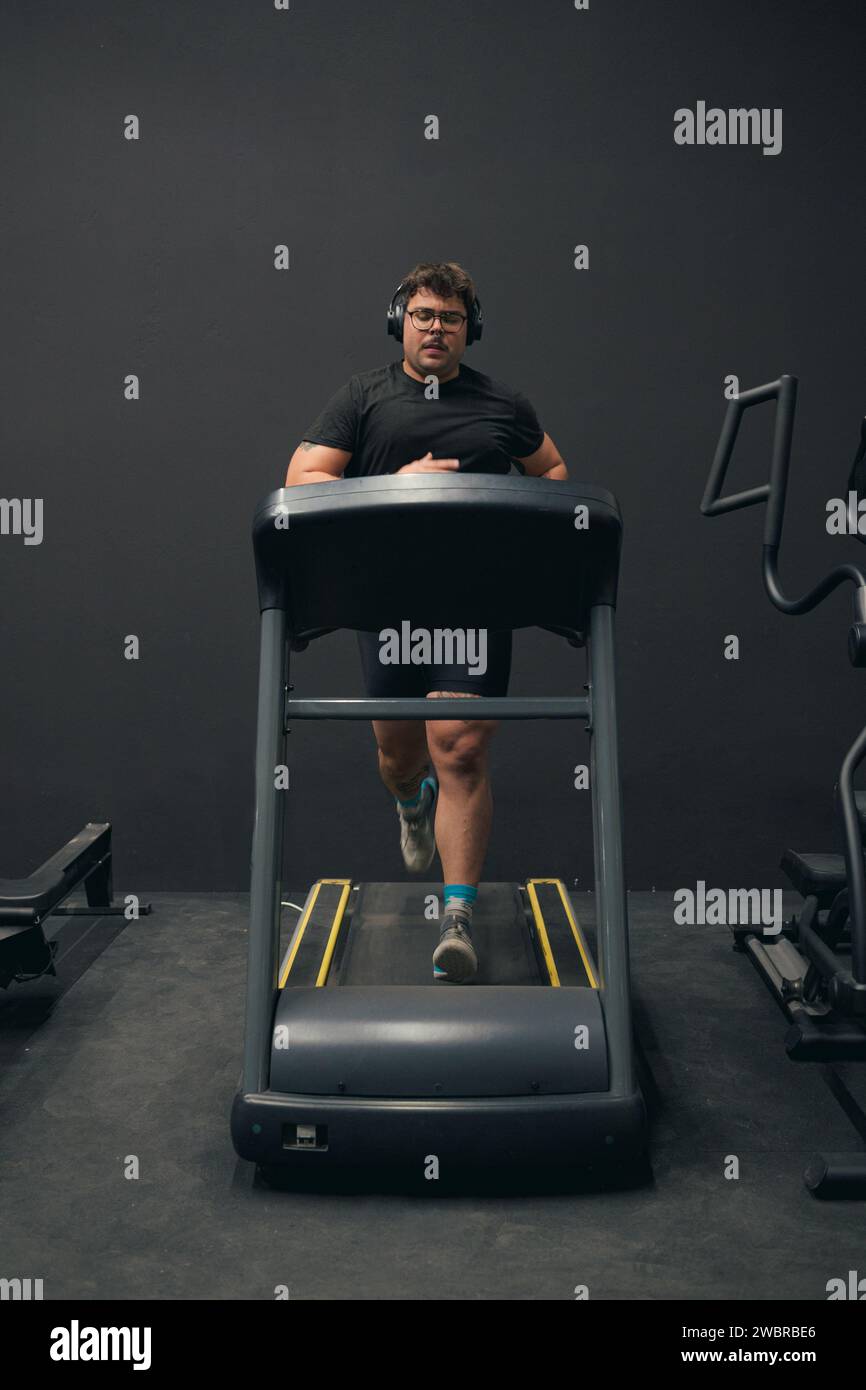 L'homme fort court et s'entraîne dans une salle de gym. Renforcement des jambes Banque D'Images