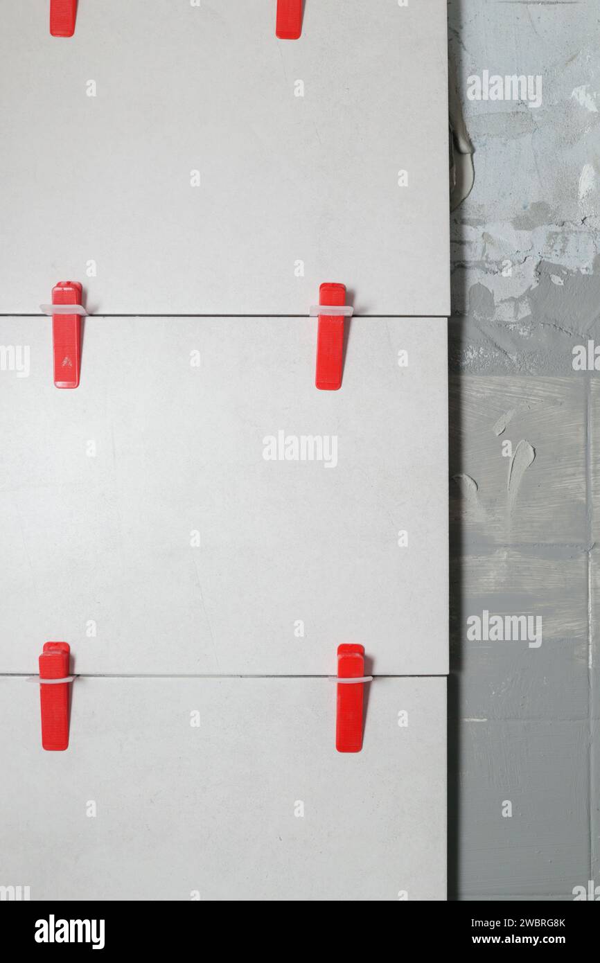 SYSTEME de nivellement de carreaux en plastique pour murs plats. Processus d'installation de carreaux dans la salle de bain étape par étape. Amélioration de la maison DIY. Banque D'Images