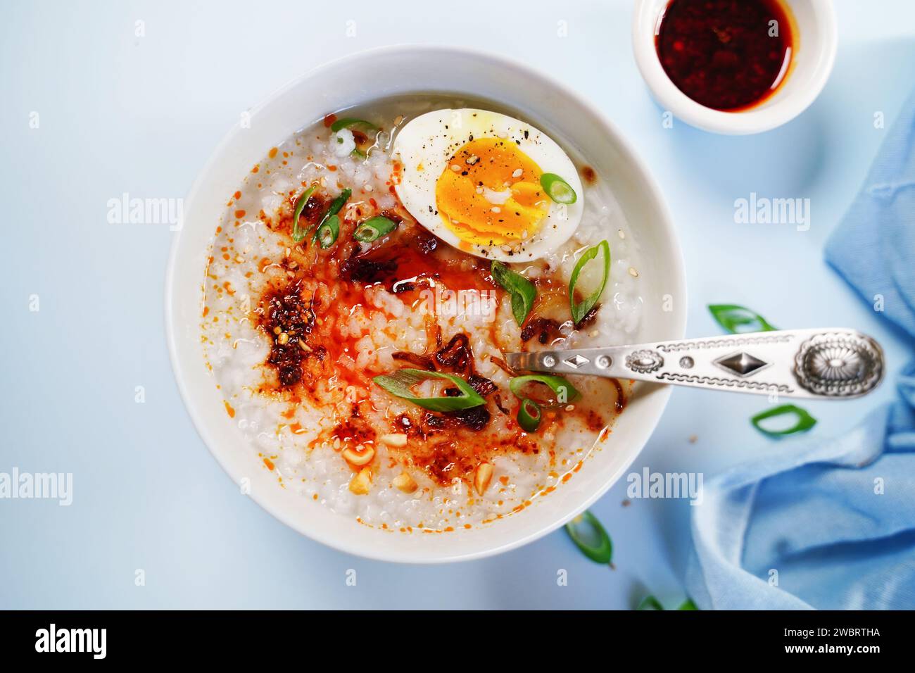 Congee maison de style asiatique chinois avec des échalotes frites aux œufs durs et des oignons de printemps Banque D'Images