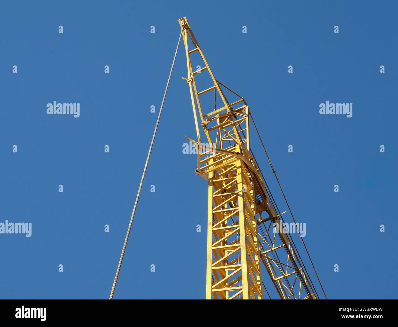 Grue à tour jaune sur un chantier de construction au-dessus de Blue Sky Banque D'Images