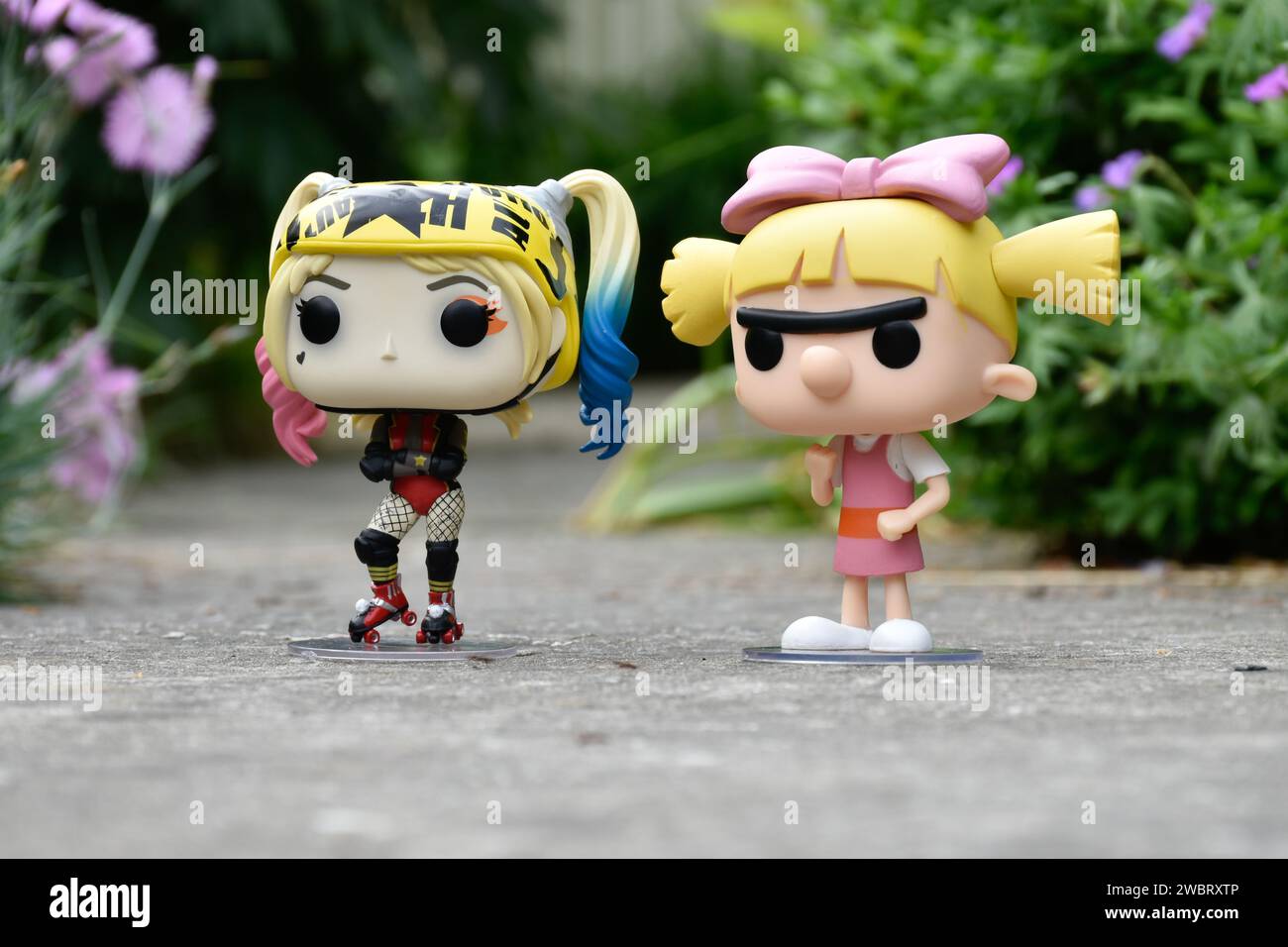 Funko Pop figurines d'action de DC comics super-héros Harley Quinn et Helga Pataki de la série télévisée d'animation Nickelodeon Hey Arnold. Route asphaltée, jardin. Banque D'Images