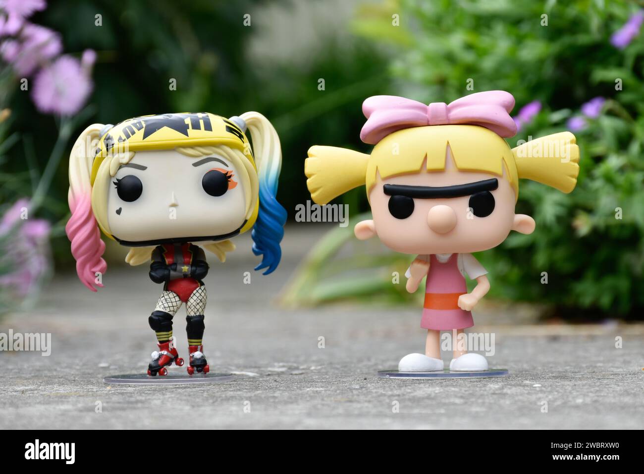 Funko Pop figurines d'action de DC comics super-héros Harley Quinn et Helga Pataki de la série télévisée d'animation Nickelodeon Hey Arnold. Route asphaltée, jardin. Banque D'Images