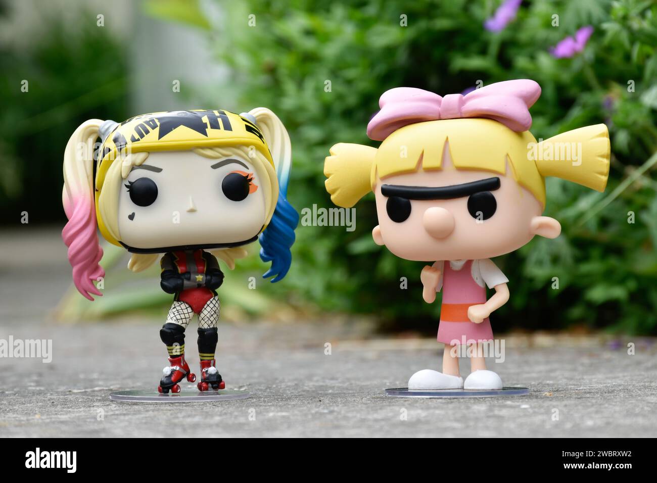 Funko Pop figurines d'action de DC comics super-héros Harley Quinn et Helga Pataki de la série télévisée d'animation Nickelodeon Hey Arnold. Route asphaltée, jardin. Banque D'Images