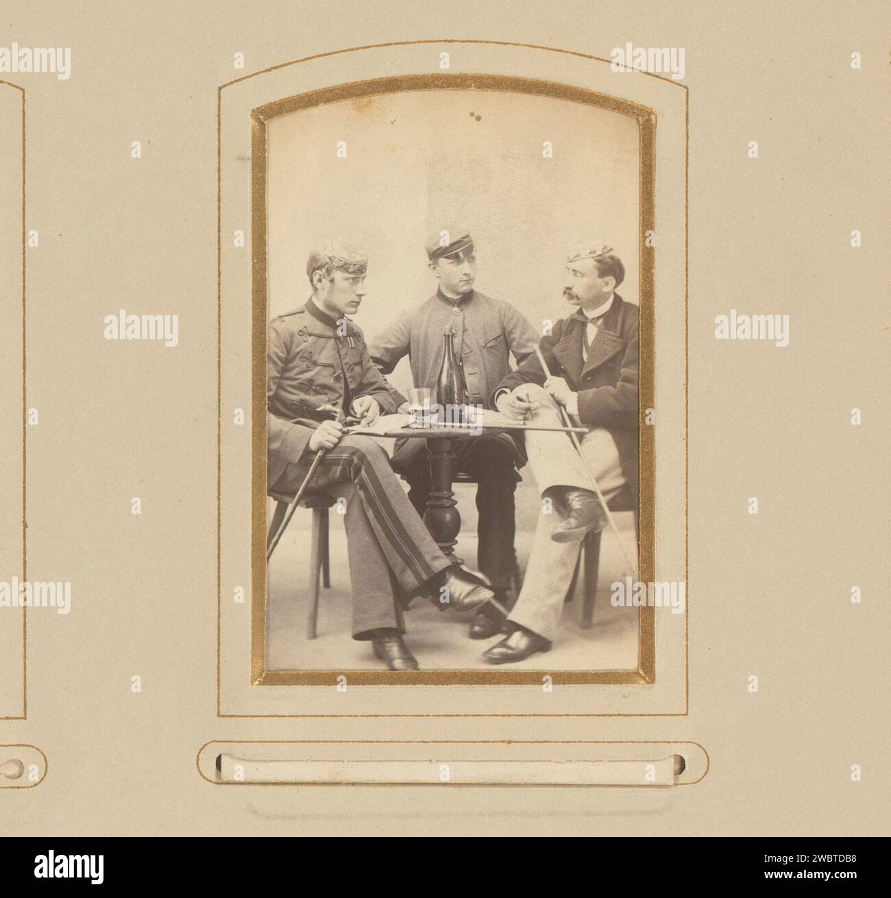Portrait de trois hommes à une table, J. Remde, 1850 - 1880 Photographie. Carte de visite cette photo fait partie d'un album. Carton Ironach. support photographique albumen print personnes historiques anonymes dépeintes dans un groupe, dans un portrait de groupe. homme adulte (+ trois personnes). tableau Banque D'Images