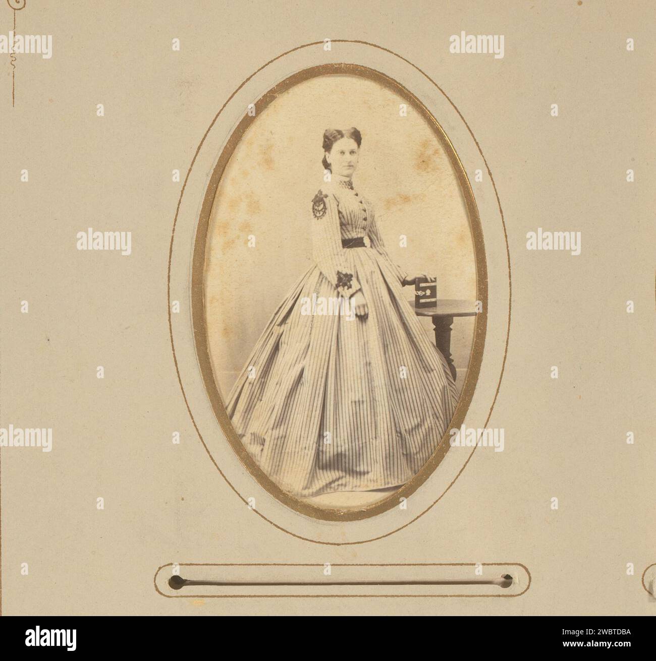 Portrait d'une femme debout avec une main sur un livre, J. Remde, 1850 - 1880 Photographie. Carte de visite cette photo fait partie d'un album. Carton Ironach. Support photographique albumen print personnes historiques - BB - femme. livre Banque D'Images