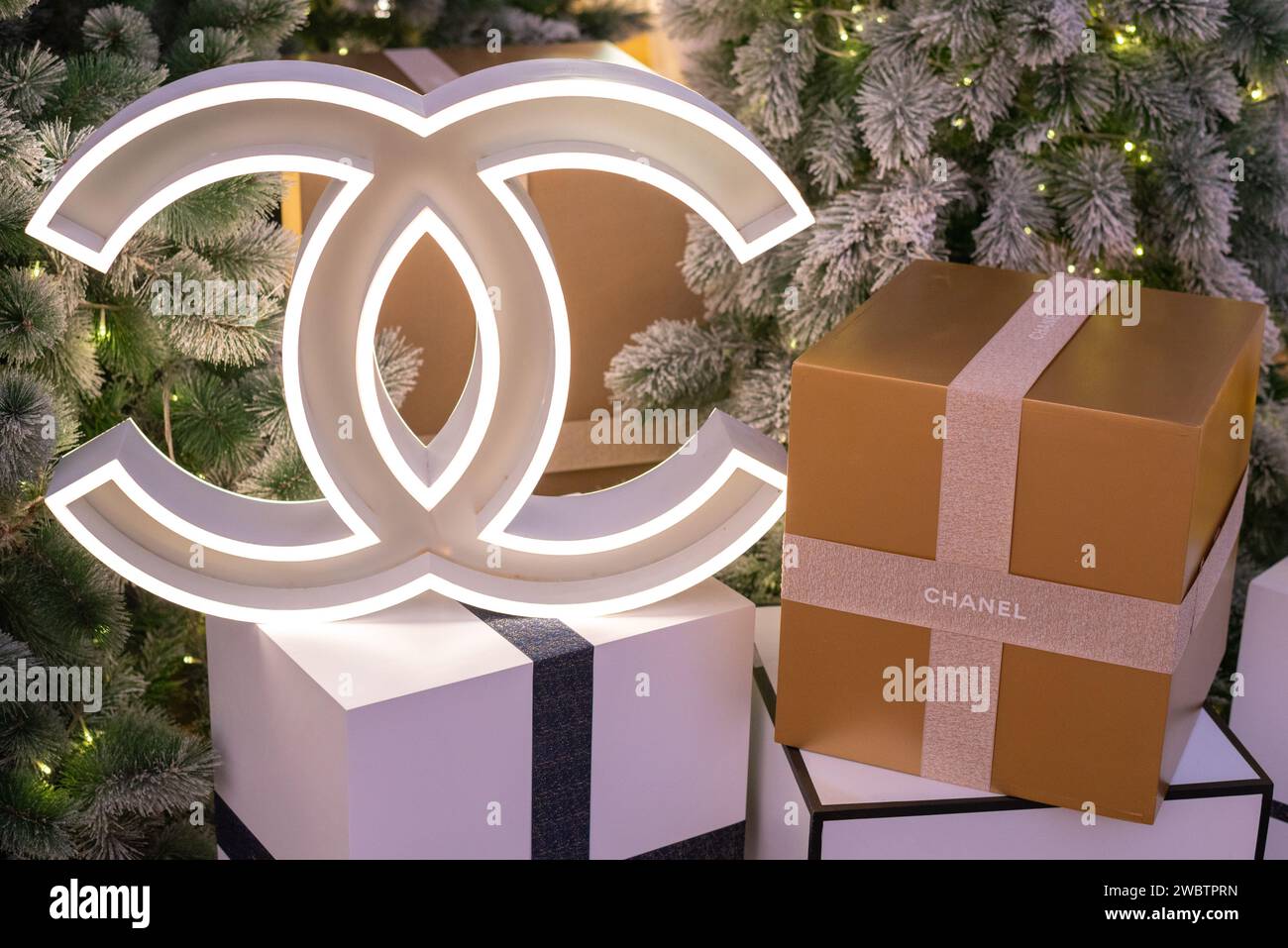 Modèle lumineux de logo Chanel & boîte cadeau avec ruban avec inscription Chanel avec sapin de Noël le 17 décembre 2023, à Bangkok, Thaïlande Banque D'Images