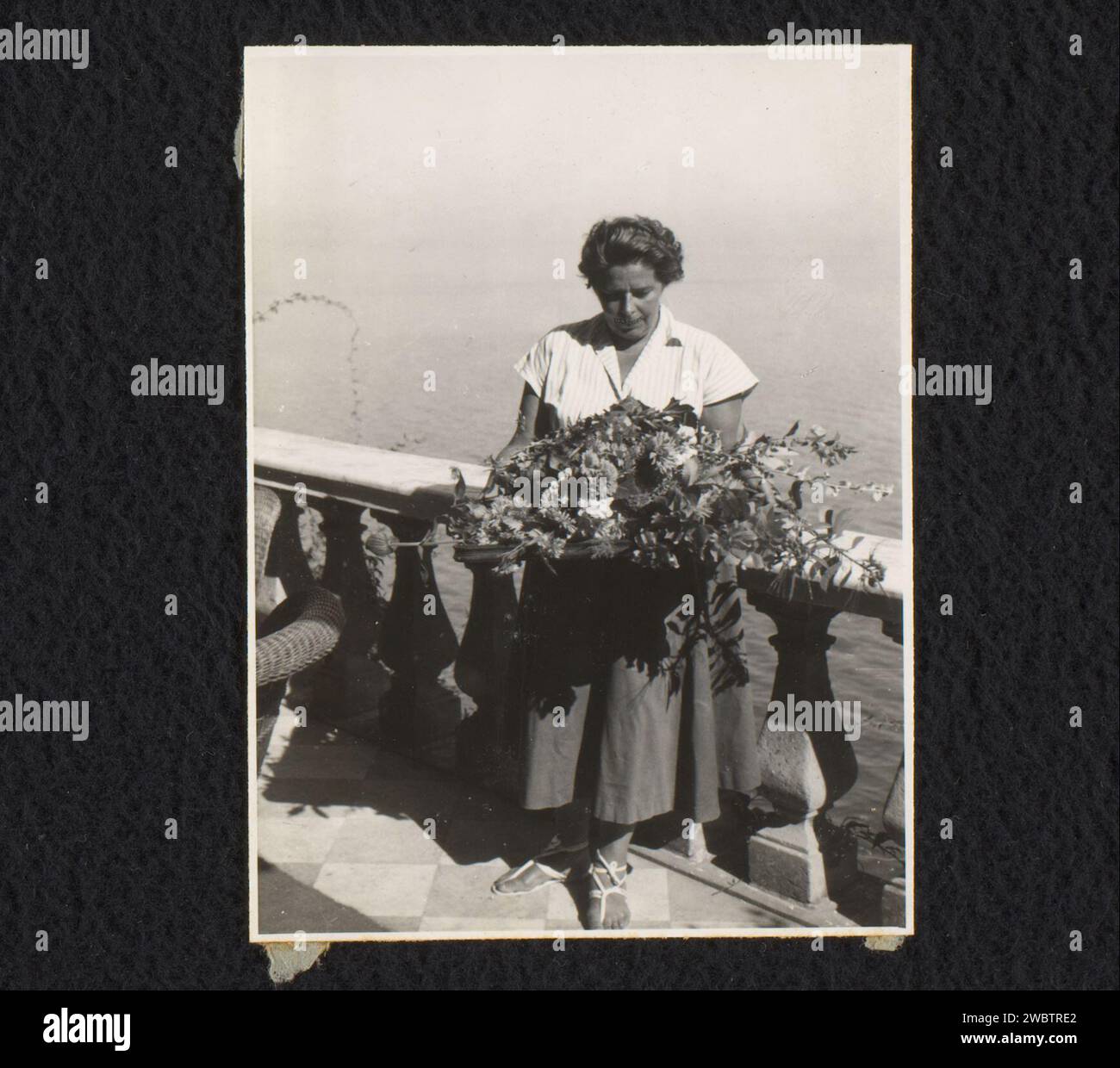 Femme aux fleurs devant une balustrade dans le jardin de Villa Tritone, Sorrente, Norbert van den Berg (1901-1972), c. 1950 photographie cette photo est en vrac dans l'album. Sorrento baryta papier gélatine argentique villa imprimée. jardin. Personnes historiques - BB - femme Tritone villa Banque D'Images