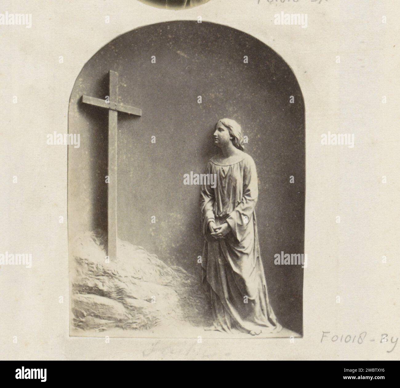 Production photographique d'une œuvre d'art avec une femme priante sous une croix, peut-être un relief, anonyme, c. 1860 - c. 1870 photographie partie d'un album de famille anglais avec des photos de personnes, de voyages, de cricket et d'œuvres d'art. papier. Support photographique Albumen imprimer la croix  symboles du Christ. une personne priant Banque D'Images