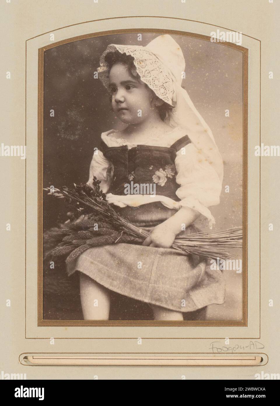 Portrait d'une fille assise en costumes traditionnels avec chapeau blanc, maïs à la main, E. Vogelsang, photographie de 1884. Cabinet photographie cette photo fait partie d'un album. Berlin carton. support photographique albumen tête d'impression-engrenage : capuchon. Personnes historiques - BB - femme. enfant en bas âge (femelle). épi de maïs Banque D'Images