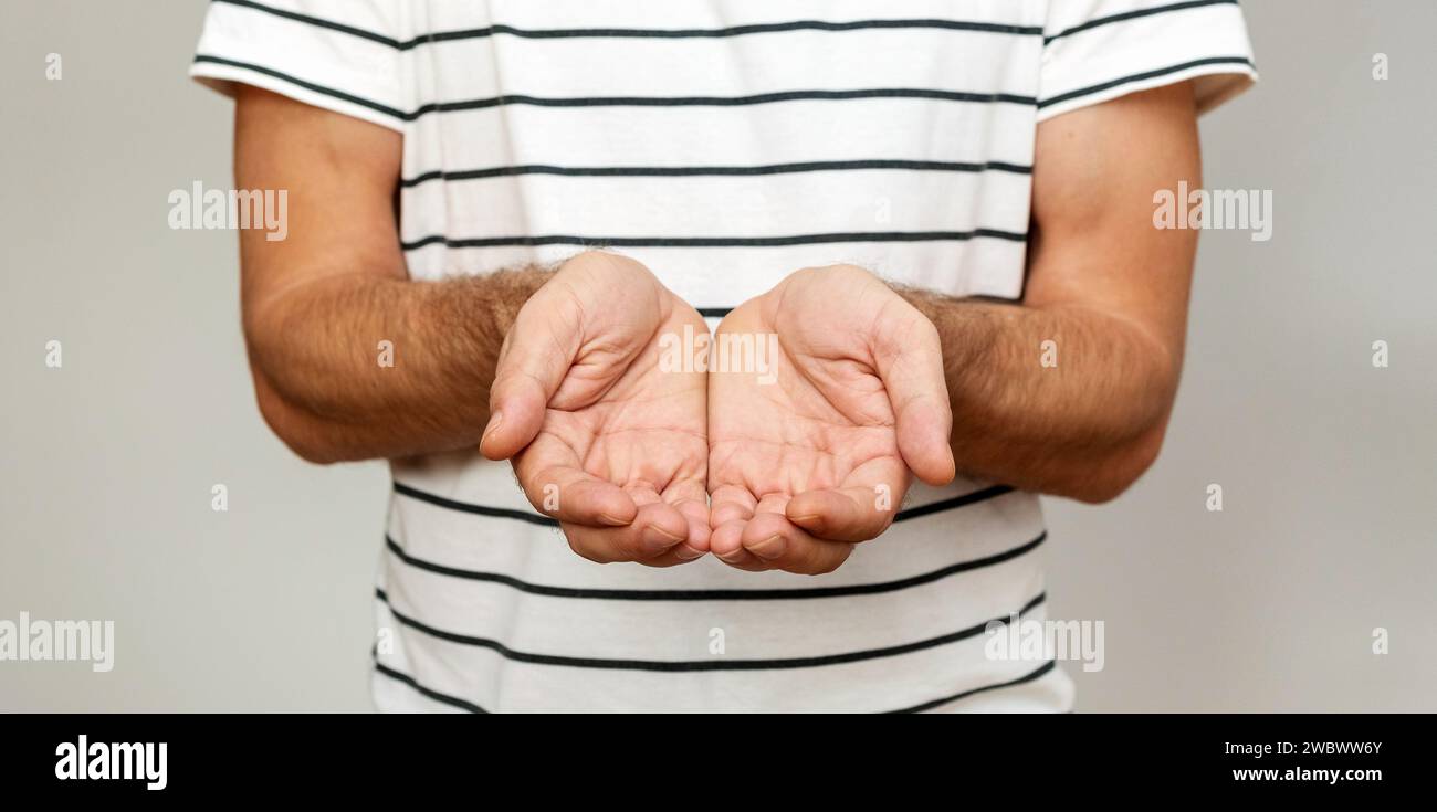 Homme tenant les mains avec les paumes vers le haut. Banque D'Images
