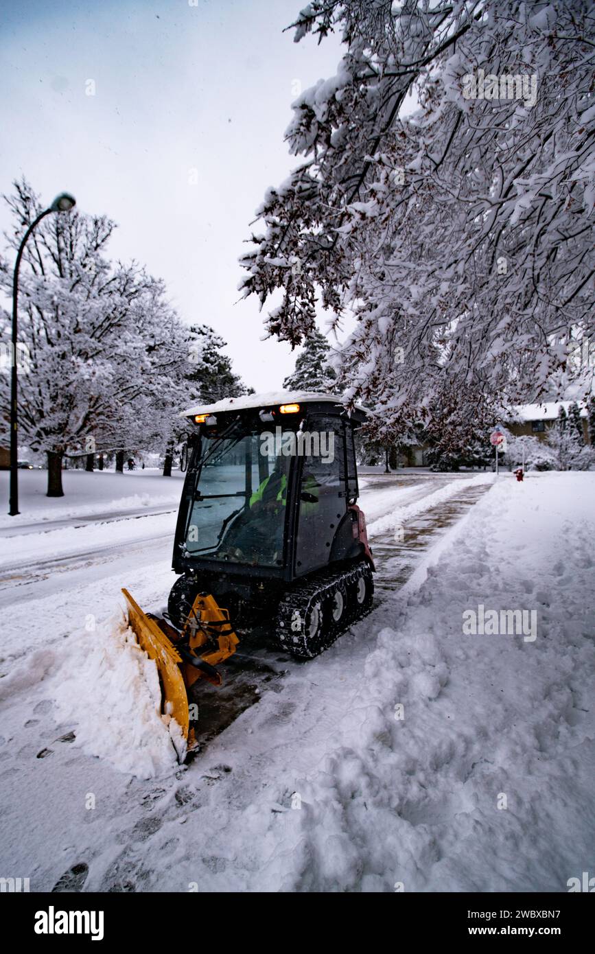 Un grand chasse-neige est stationnaire le long du bord de la route, prêt à déneiger et à assurer un passage sécuritaire dans la rue Banque D'Images