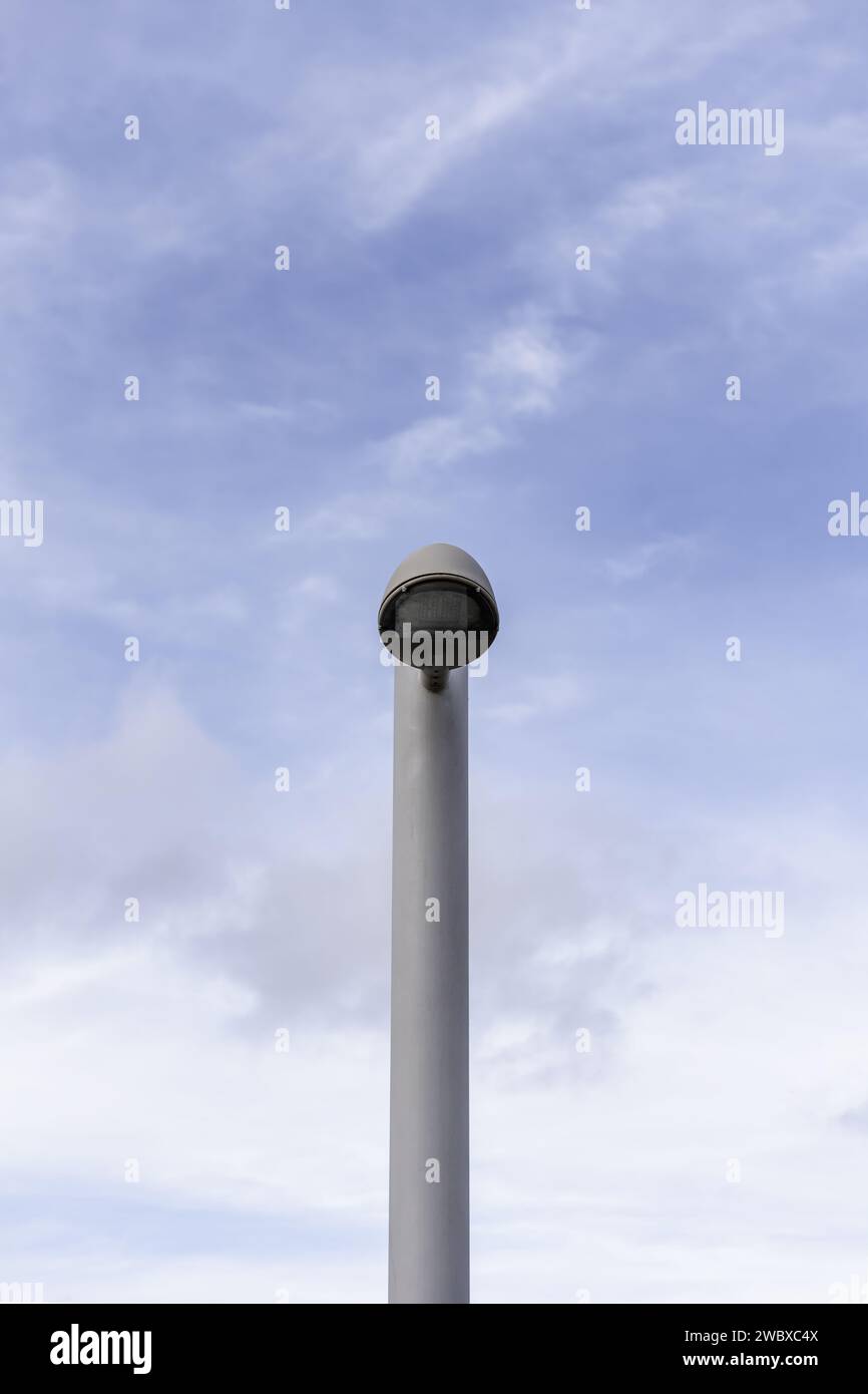 Un lampadaire en métal solitaire dans un style moderne avec des lampes LED et un fond du ciel avec des nuages Banque D'Images