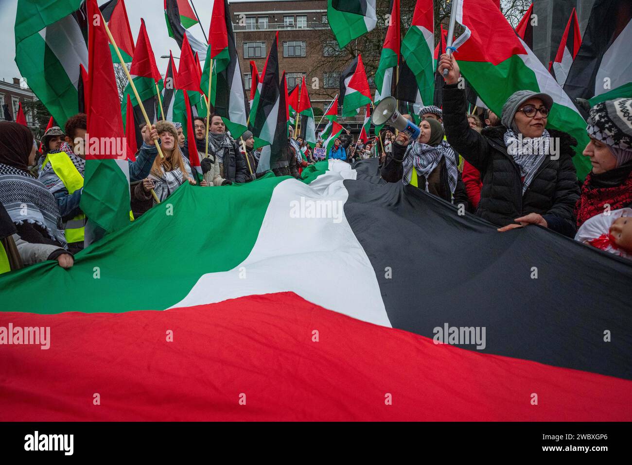 La Haye, Hollande du Sud, pays-Bas. 12 janvier 2024. Les manifestants brandissent un drapeau palestinien géant. Le 12 janvier 2024, des militants pro-israéliens et pro-palestiniens ont manifesté devant la Cour internationale de Justice à la Haye. À l'intérieur de la Cour, Israël s'est défendu contre l'accusation de génocide de l'Afrique du Sud. (Image de crédit : © James Petermeier/ZUMA Press Wire) USAGE ÉDITORIAL SEULEMENT! Non destiné à UN USAGE commercial ! Banque D'Images