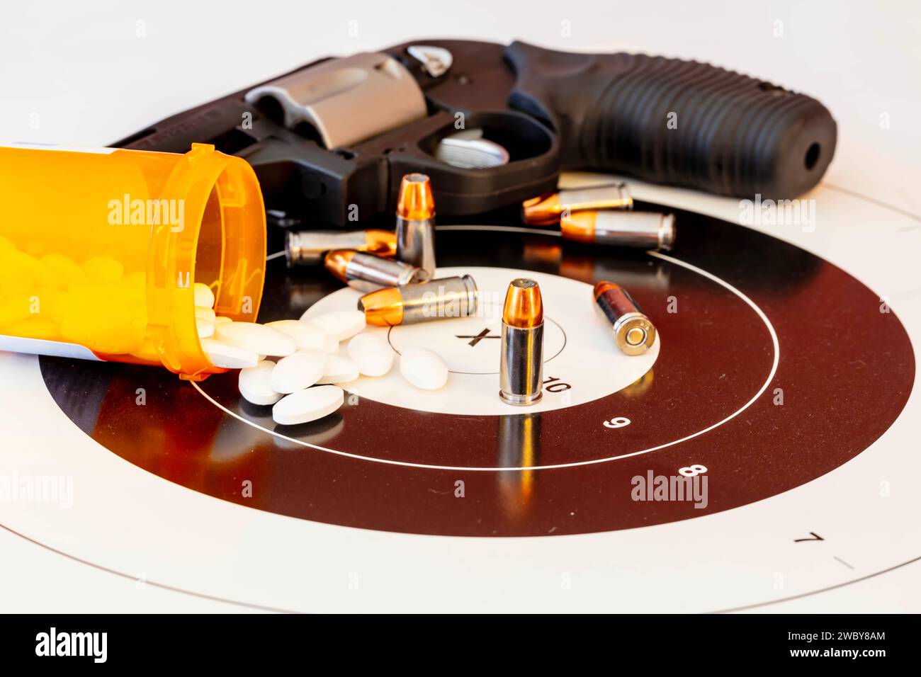 Harrisburg, Caroline du Nord, États-Unis. 3 mai 2017. Tableau dangereux : les pilules illicites coexistent avec un pistolet chargé et des balles sur une cible, une convergence effrayante de la toxicomanie et de la violence potentielle. (Image de crédit : © Walter G Arce SR Grindstone Medi/ASP) USAGE ÉDITORIAL SEULEMENT! Non destiné à UN USAGE commercial ! Banque D'Images