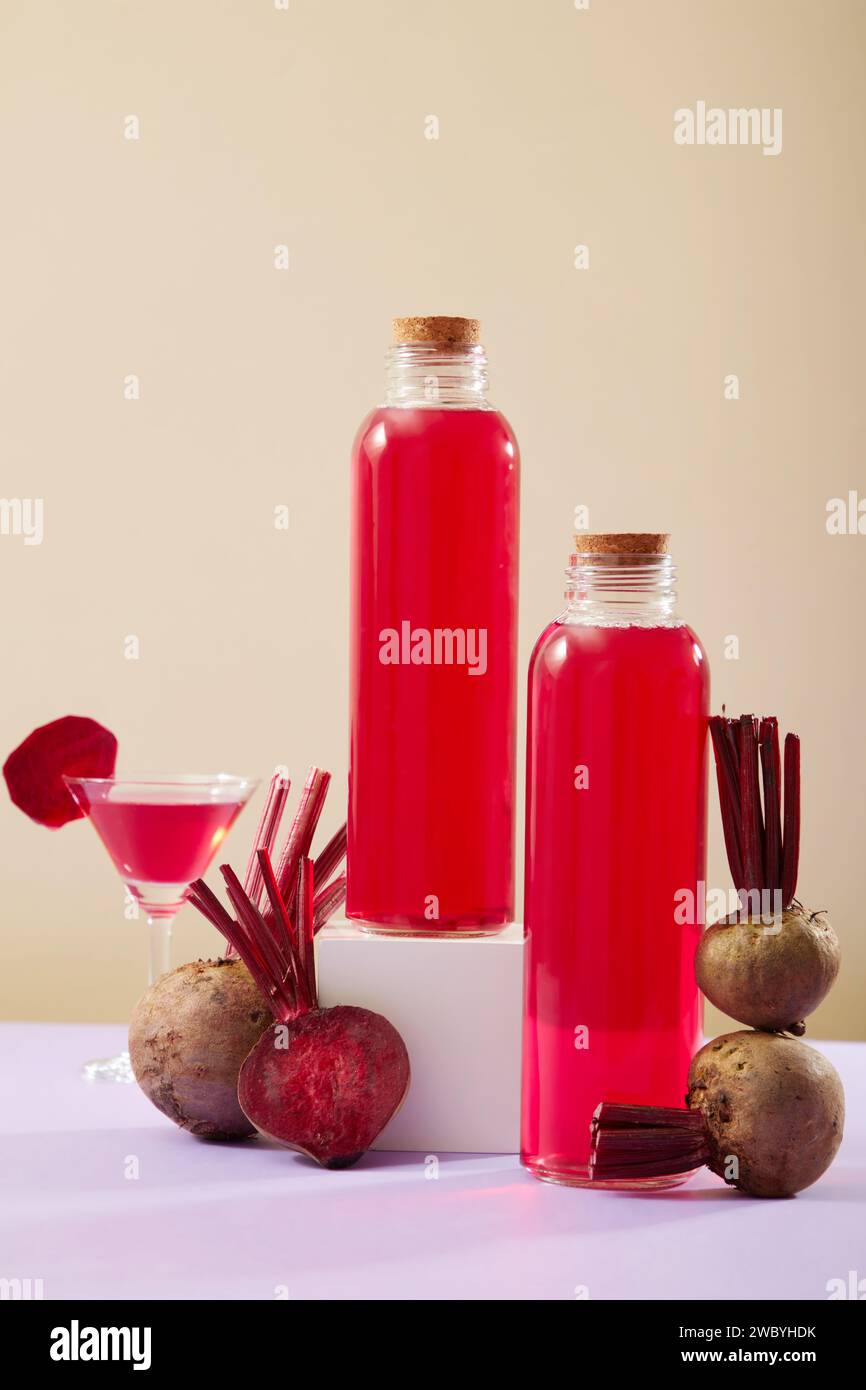 Concept de fruits frais avec quelques betteraves disposées avec un verre et des bouteilles non étiquetées remplies de jus de betterave. Les bienfaits pour la santé de Beetroot (Beta Banque D'Images