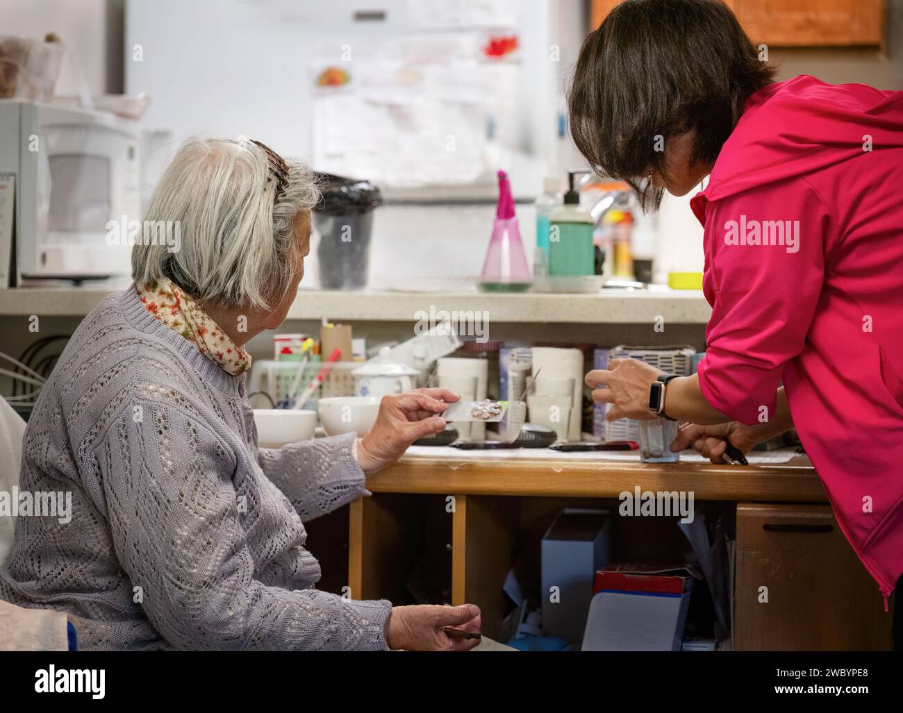 Fille et femme âgée triant les pilules de médecine à la maison. Banque D'Images