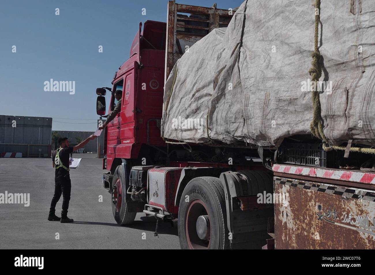 Des camions transportant des fournitures d'aide humanitaire arrivent d'Égypte du côté israélien du terminal de Karem Abu Salem, également connu sous le nom de terminal de Kerem Shalom, pour subir un contrôle de sécurité avant d'entrer dans le Sud de la bande de Gaza le 10 janvier 2024 à la frontière de Gaza, en Israël. Banque D'Images