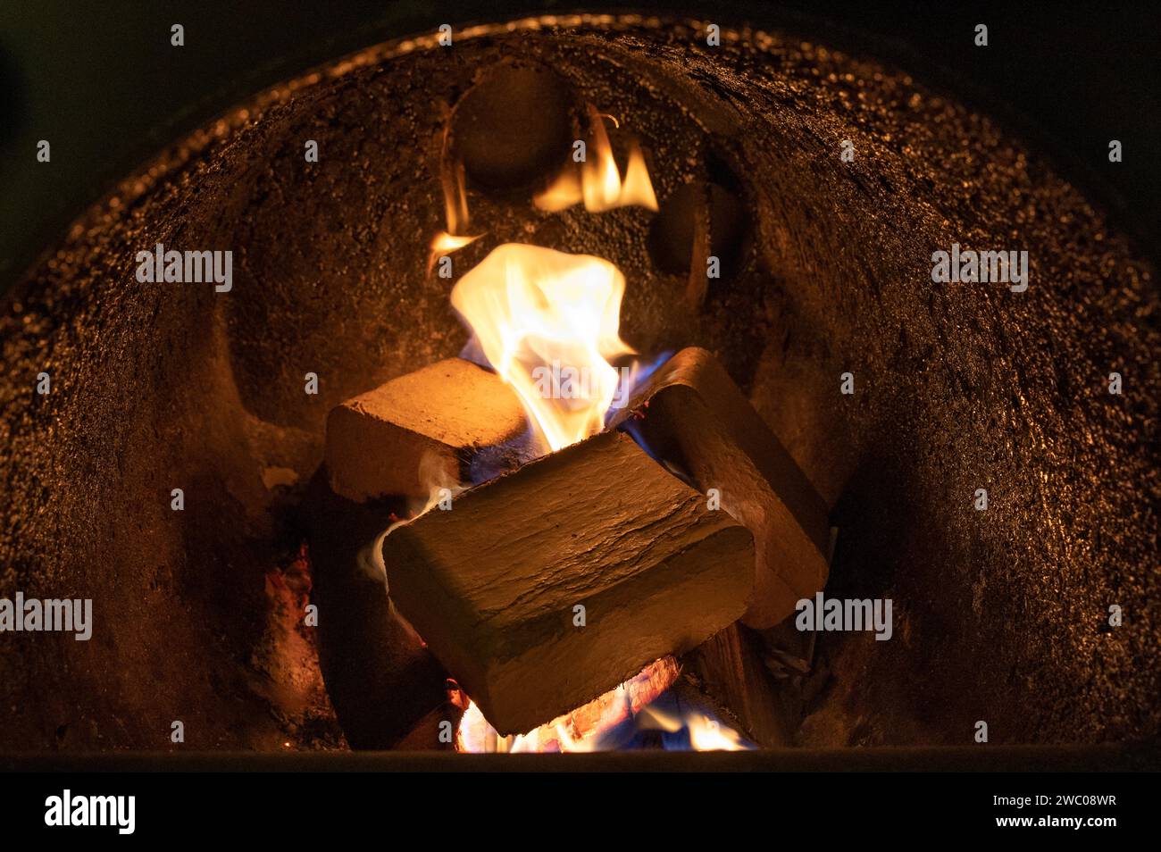 Briquettes de bois (type ruf), en hêtre et chêne brûlant à l'intérieur de la chaudière à bois. Carburant alternatif, éco-carburant, bio-carburant. Banque D'Images