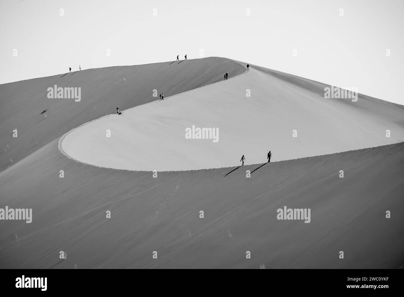 Les touristes font leur chemin le long des lignes de crête des immenses dunes de sable à Sossusvlei vers la dune Big Daddy en Namibie Banque D'Images