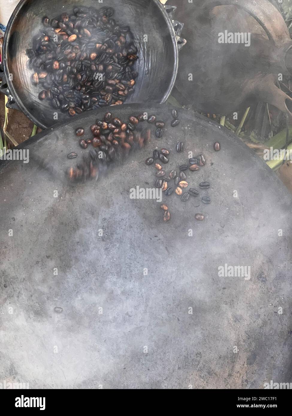 grains de café torréfiés à la main de manière traditionnelle sur un poêle à bois vu d'en haut à travers la fumée Banque D'Images