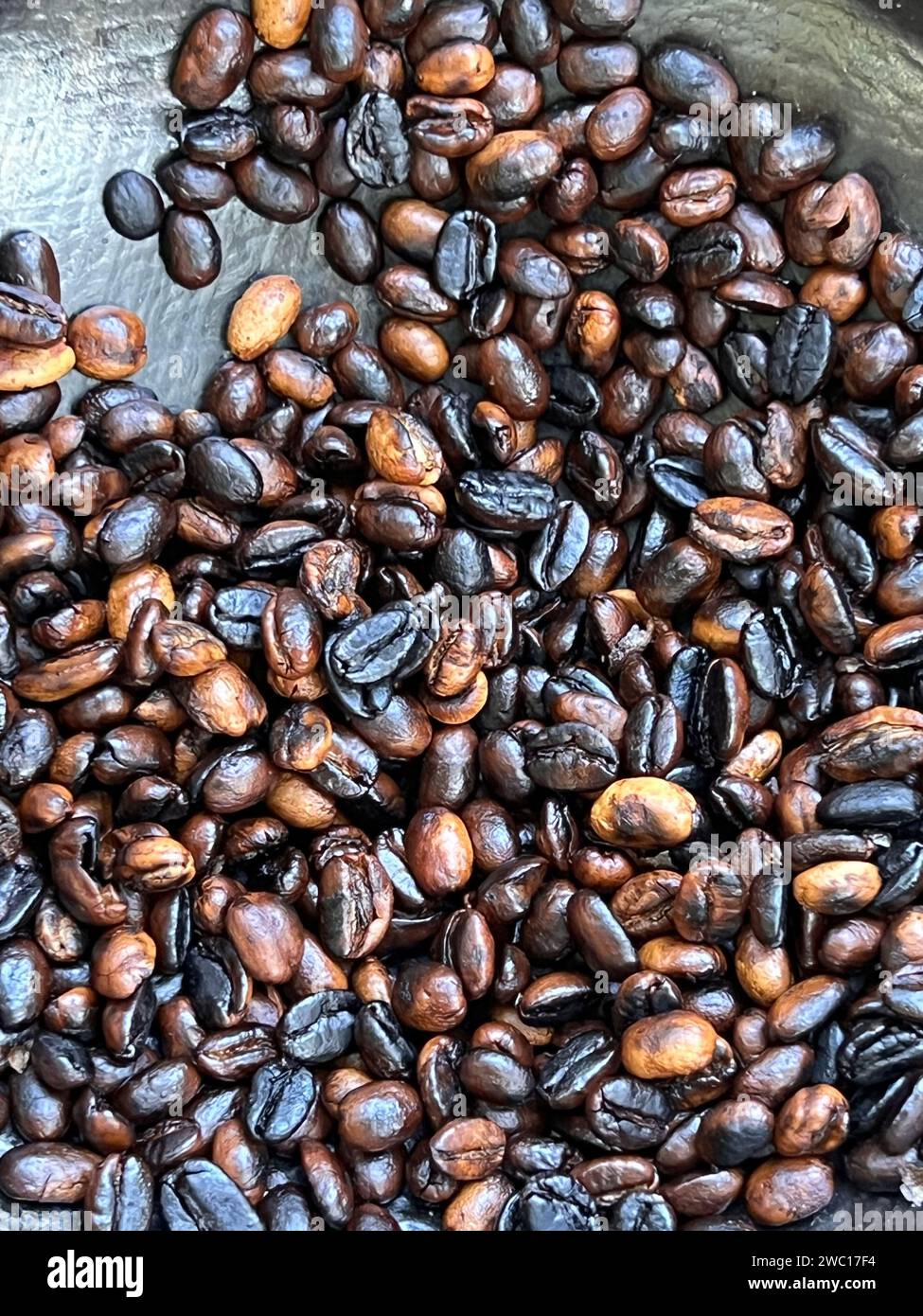 grains de café torréfiés à la main de manière traditionnelle sur un poêle à bois. Banque D'Images