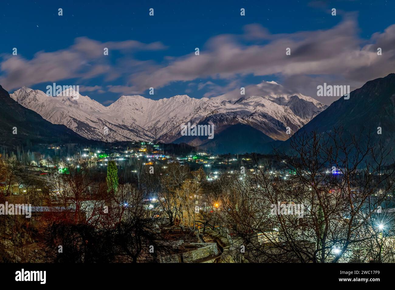 paysage nocturne de montagnes de neige lumières et arbres, montagnes enneigées avec ciel bleu et nuages blancs Banque D'Images