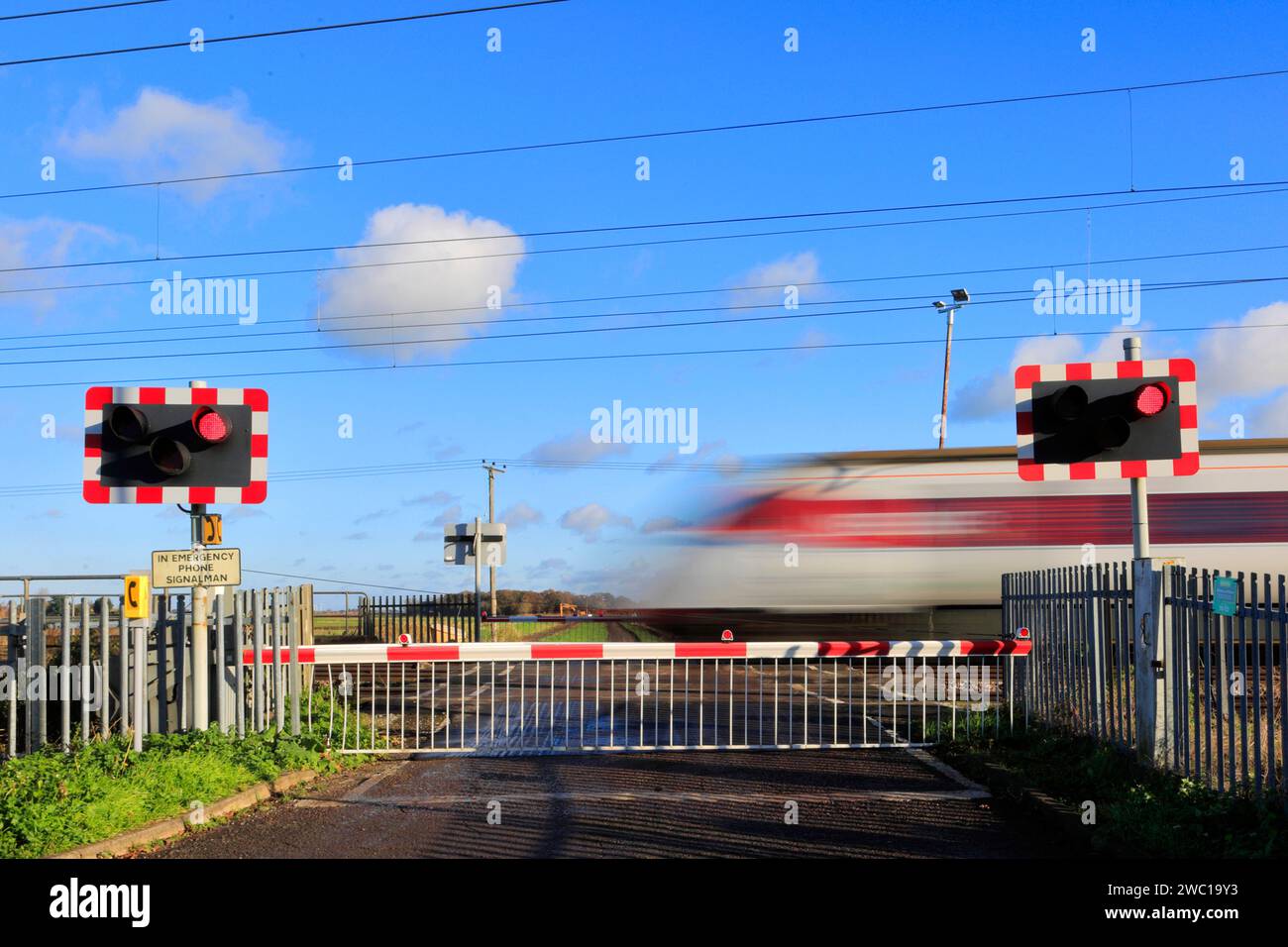 Un train Azuma passant des feux rouges à un passage à niveau sans pilote, East Coast main Line Railway, Holme, Cambridgeshire, Angleterre, Royaume-Uni Banque D'Images