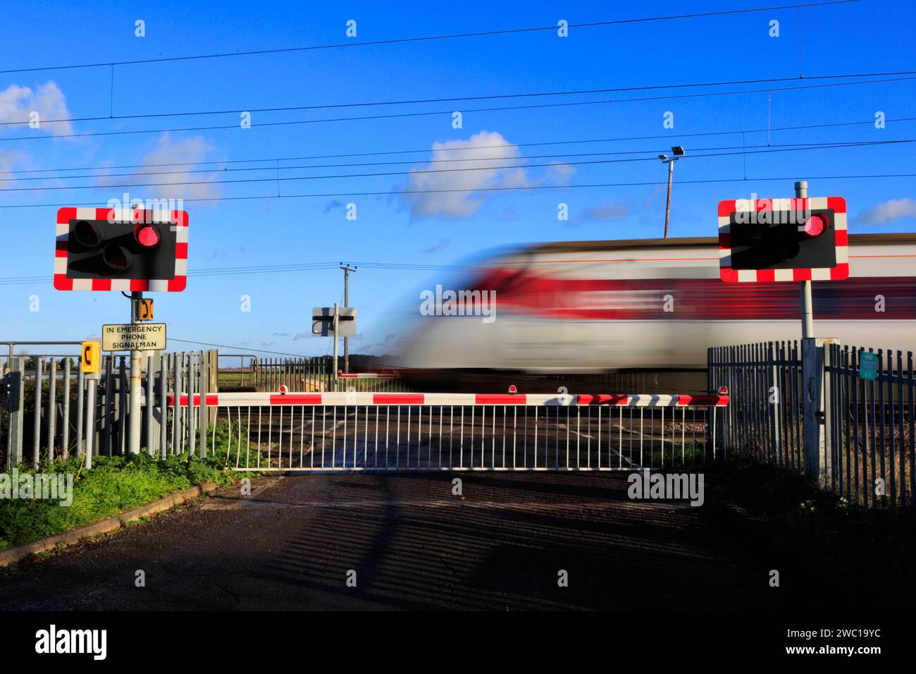 Un train Azuma passant des feux rouges à un passage à niveau sans pilote, East Coast main Line Railway, Holme, Cambridgeshire, Angleterre, Royaume-Uni Banque D'Images