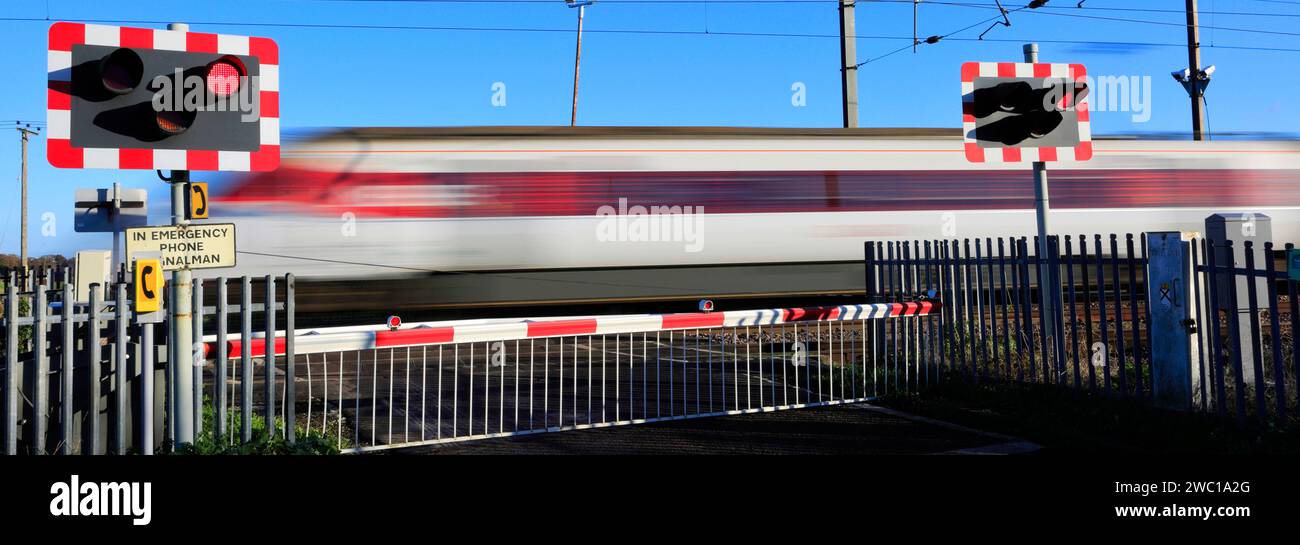 Un train Azuma passant des feux rouges à un passage à niveau sans pilote, East Coast main Line Railway, Holme, Cambridgeshire, Angleterre, Royaume-Uni Banque D'Images
