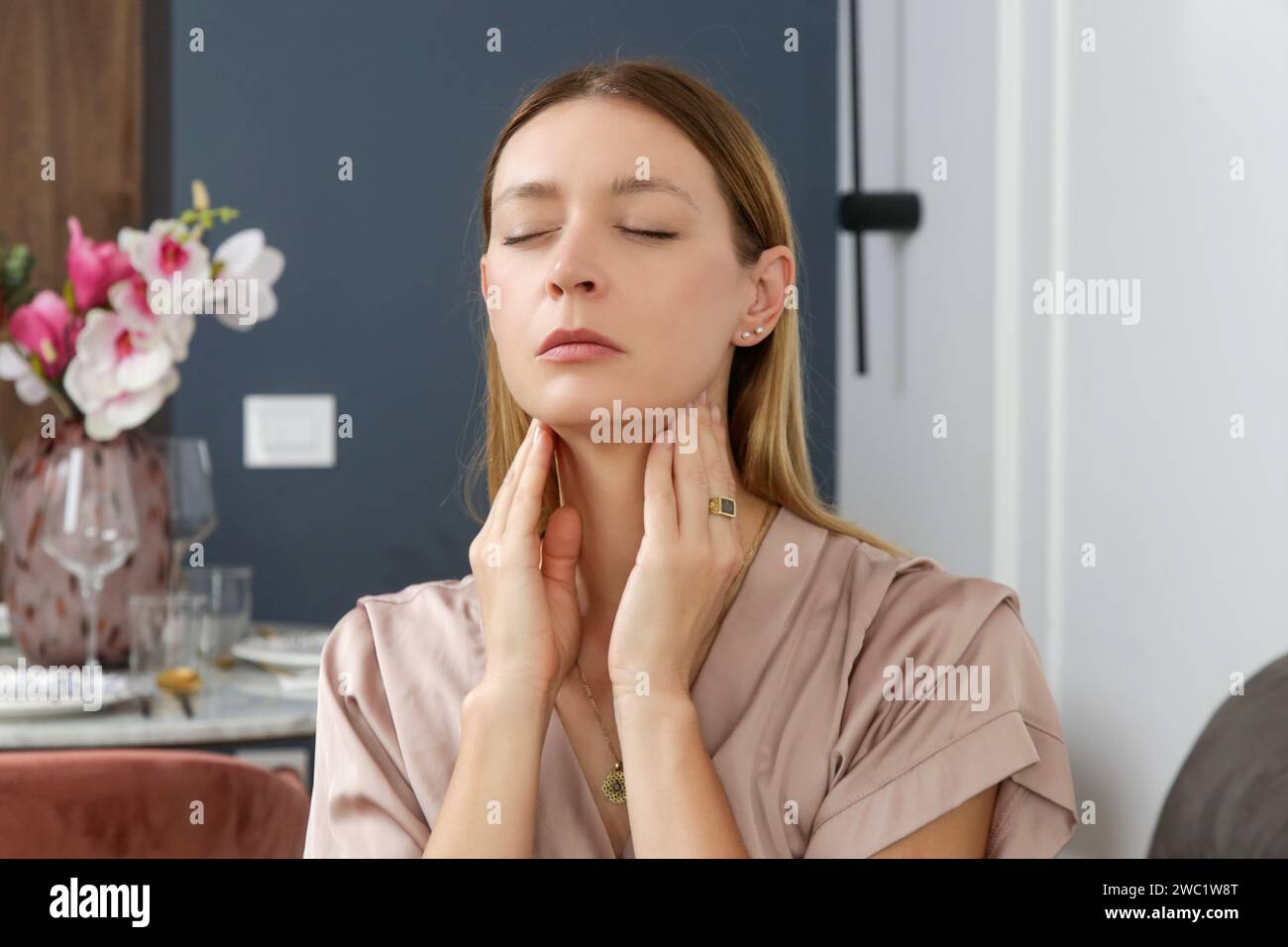 Femme caucasienne touchant sa gorge. Mal de gorge, rhume, grippe, amygdalite ou problème de glande thyroïde Banque D'Images