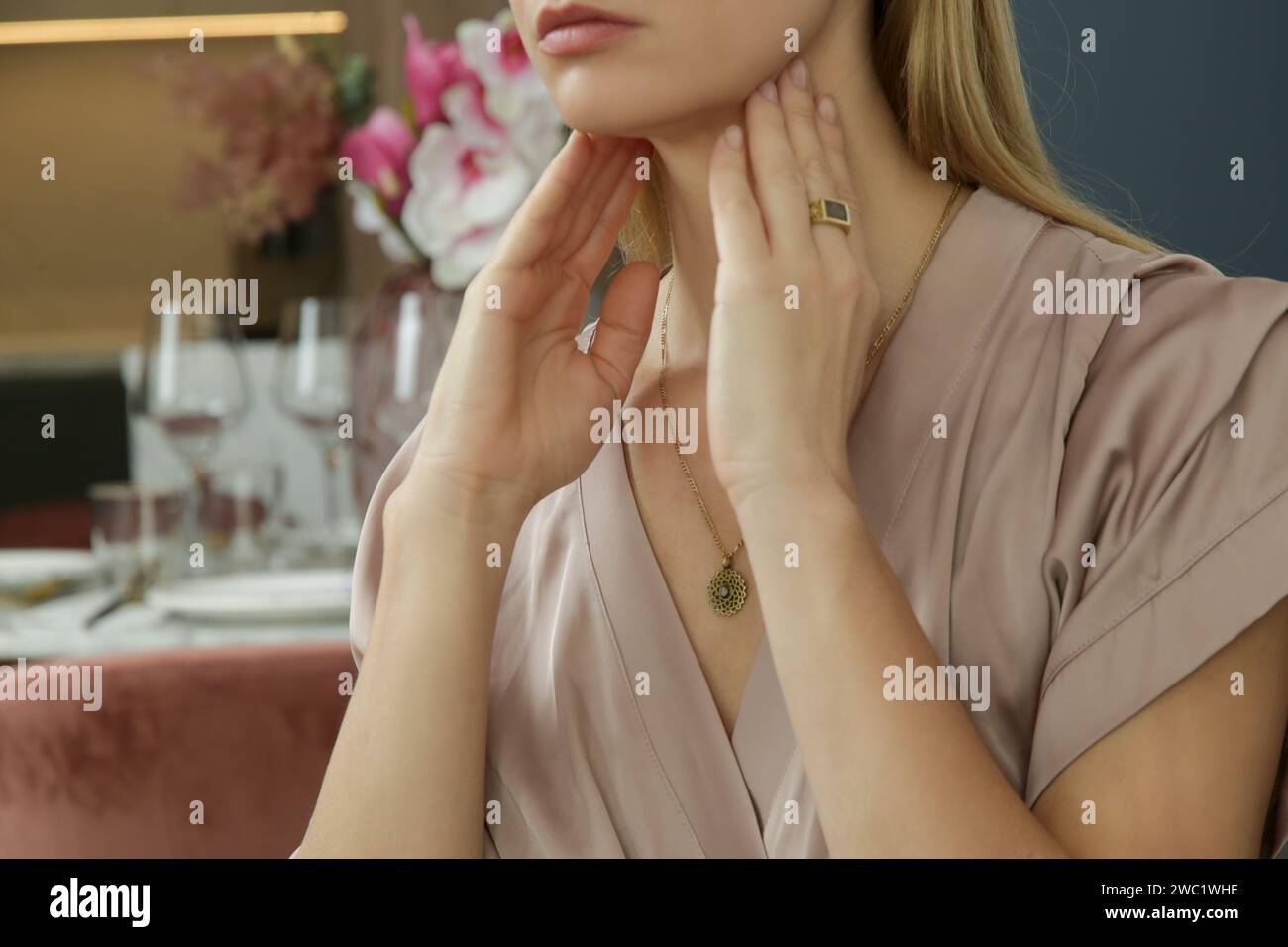 Femme caucasienne touchant sa gorge. Mal de gorge, rhume, grippe, amygdalite ou problème de glande thyroïde Banque D'Images