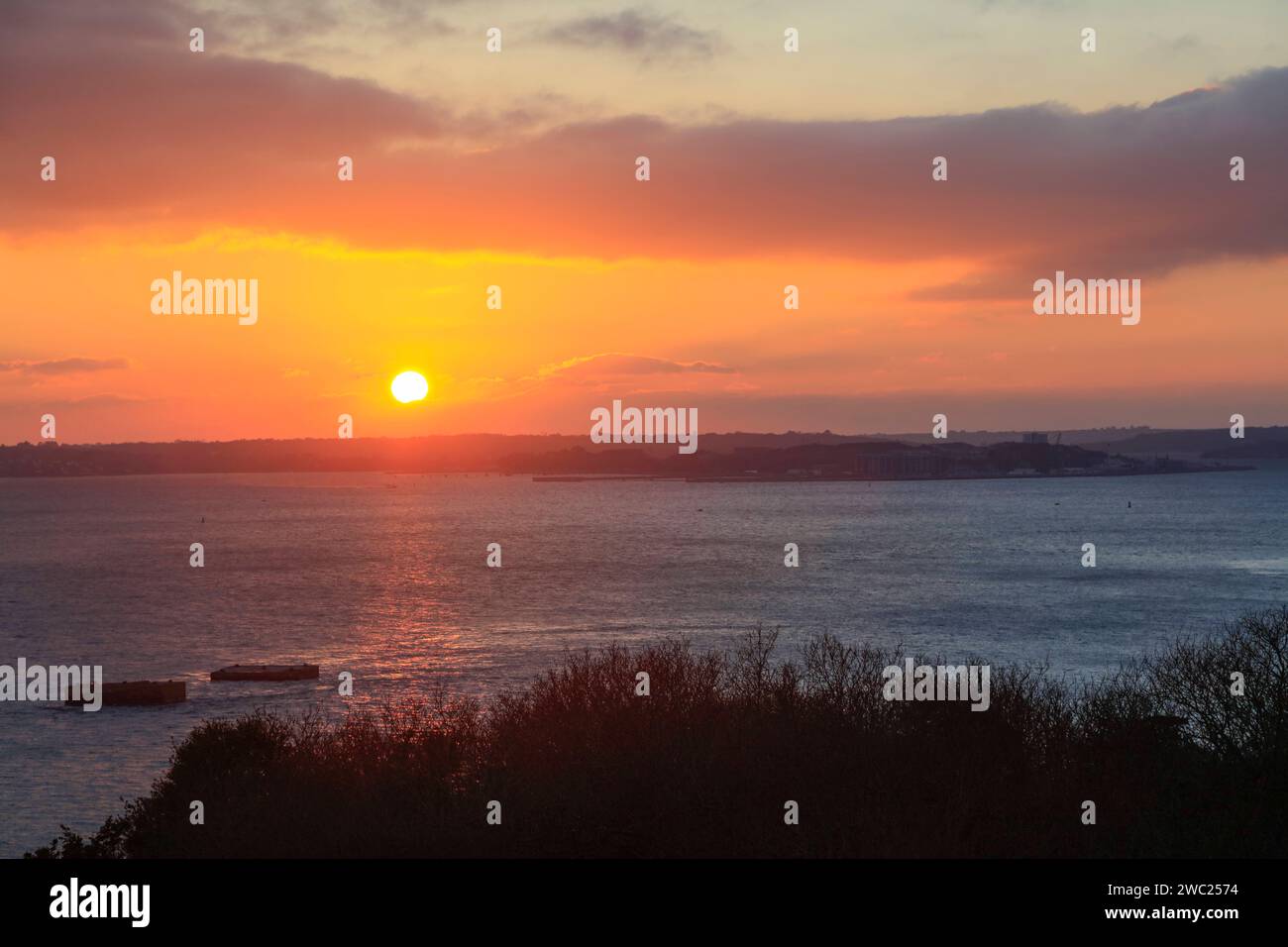 Blick BEI Sonnenuntergang von der Pointe de l Armorique über die Bucht Rade de Brest, hinten die Halbinsel Presqu ile de Crozon mit der Ile longue, Basis strategische Atom-U-Boote der französische Marine, Links die zwei von der deutschen Marine im zweiter Weltkrieg gebauten Dalben, an denen das Schlachtschiff Bismarck anlegen sollte, Halbinsel Plougastel-Daoulas, Département Finistère Penn-ar-Bed, région Bretagne Breizh, Frankreich *** vue au coucher du soleil depuis la Pointe de l'Armorique sur la baie de Rade de Brest, derrière la presqu'île de Crozon avec l'Ile longue, base nucléaire stratégique Banque D'Images