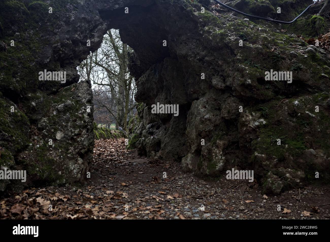 Passage sous une formation rocheuse dans un parc par une journée nuageuse en automne Banque D'Images