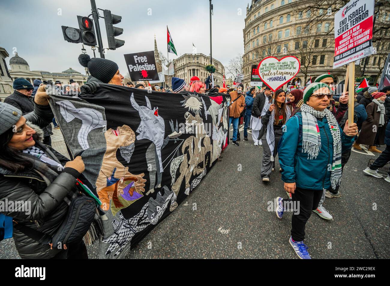 Londres, Royaume-Uni. 13 janvier 2024. Une tapisserie basée sur la manifestation Guernica - Palestine de PICASO, appelant à un cessez-le-feu, marche maintenant de Bank à Westminster avec des discours divisés entre Parliament Square et Trafalgar Square en raison du nombre attendu. La foule continue de réagir à la dernière flambée de violence et à la réponse israélienne à Gaza. La manifestation a été organisée par Stop the war, la Palestine Solidarity Campaign UK et Friends of Al Aqsa, entre autres. Crédit : Guy Bell/Alamy Live News Banque D'Images