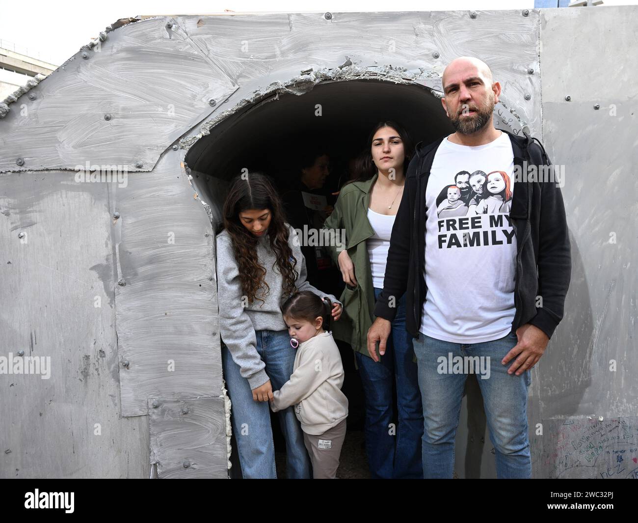 Tel Aviv, Israël. 13 janvier 2024. Des proches de la famille Bibas, dont deux petits garçons, qui sont toujours retenus en otage par le Hamas à Gaza, se tiennent à l’entrée d’un tunnel de 30 mètres de l’artiste israélien Roni Levavi sur la place des otages à tel Aviv le samedi 13 janvier 2024. Le 14 janvier, Israël marquera cent jours depuis le massacre du Hamas sur Israël et appellera à la libération des 136 otages encore détenus par le Hamas à Gaza. Photo de Debbie Hill/ crédit : UPI/Alamy Live News Banque D'Images Tel Aviv, Israël. 13 janvier 2024. Des proches de la famille Bibas, dont deux petits garçons, qui sont toujours retenus en otage par le Hamas à Gaza, se tiennent à l’entrée d’un tunnel de 30 mètres de l’artiste israélien Roni Levavi sur la place des otages à tel Aviv le samedi 13 janvier 2024. Le 14 janvier, Israël marquera cent jours depuis le massacre du Hamas sur Israël et appellera à la libération des 136 otages encore détenus par le Hamas à Gaza. Photo de Debbie Hill/ crédit : UPI/Alamy Live News Banque D'Images