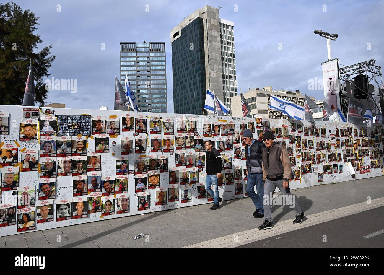 Tel Aviv, Israël. 13 janvier 2024. Les gens passent devant un mur avec des photos d’Israéliens toujours retenus en otage à Gaza par le Hamas sur la place des otages à tel Aviv le samedi 13 janvier 2024. Le 14 janvier, Israël marquera cent jours depuis le massacre du Hamas sur Israël et appellera à la libération des 136 otages encore détenus par le Hamas à Gaza. Photo de Debbie Hill/ crédit : UPI/Alamy Live News Banque D'Images Tel Aviv, Israël. 13 janvier 2024. Les gens passent devant un mur avec des photos d’Israéliens toujours retenus en otage à Gaza par le Hamas sur la place des otages à tel Aviv le samedi 13 janvier 2024. Le 14 janvier, Israël marquera cent jours depuis le massacre du Hamas sur Israël et appellera à la libération des 136 otages encore détenus par le Hamas à Gaza. Photo de Debbie Hill/ crédit : UPI/Alamy Live News Banque D'Images