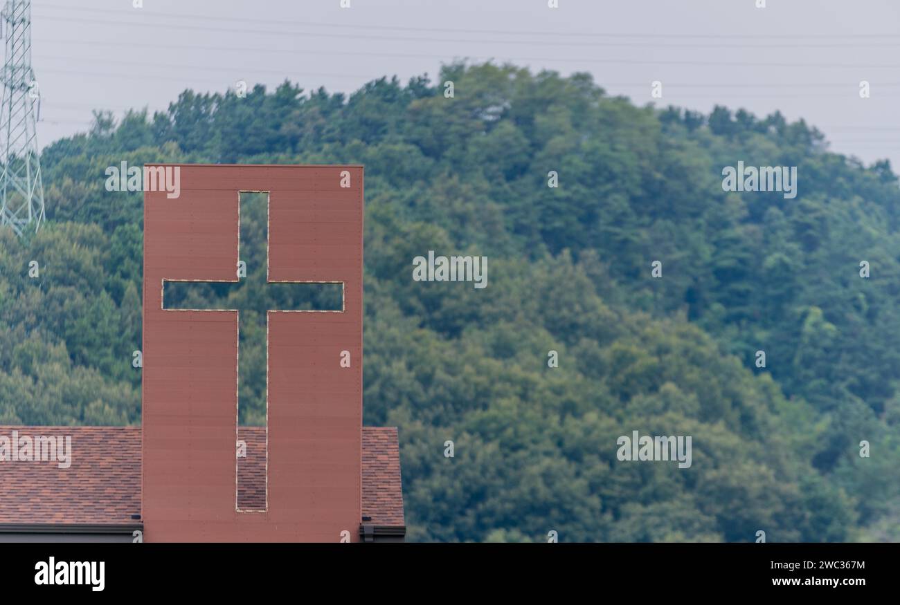 Grande croix chrétienne attachée au toit de la maison dans la campagne Banque D'Images