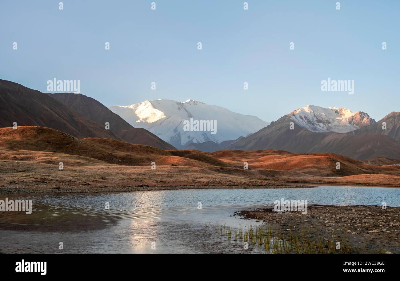 Atmosphère matinale, montagnes reflétées dans un petit lac de montagne, Pik Lenin, Trans Alay Mountains, Pamir Mountains, Osh province, Kirghizistan Banque D'Images