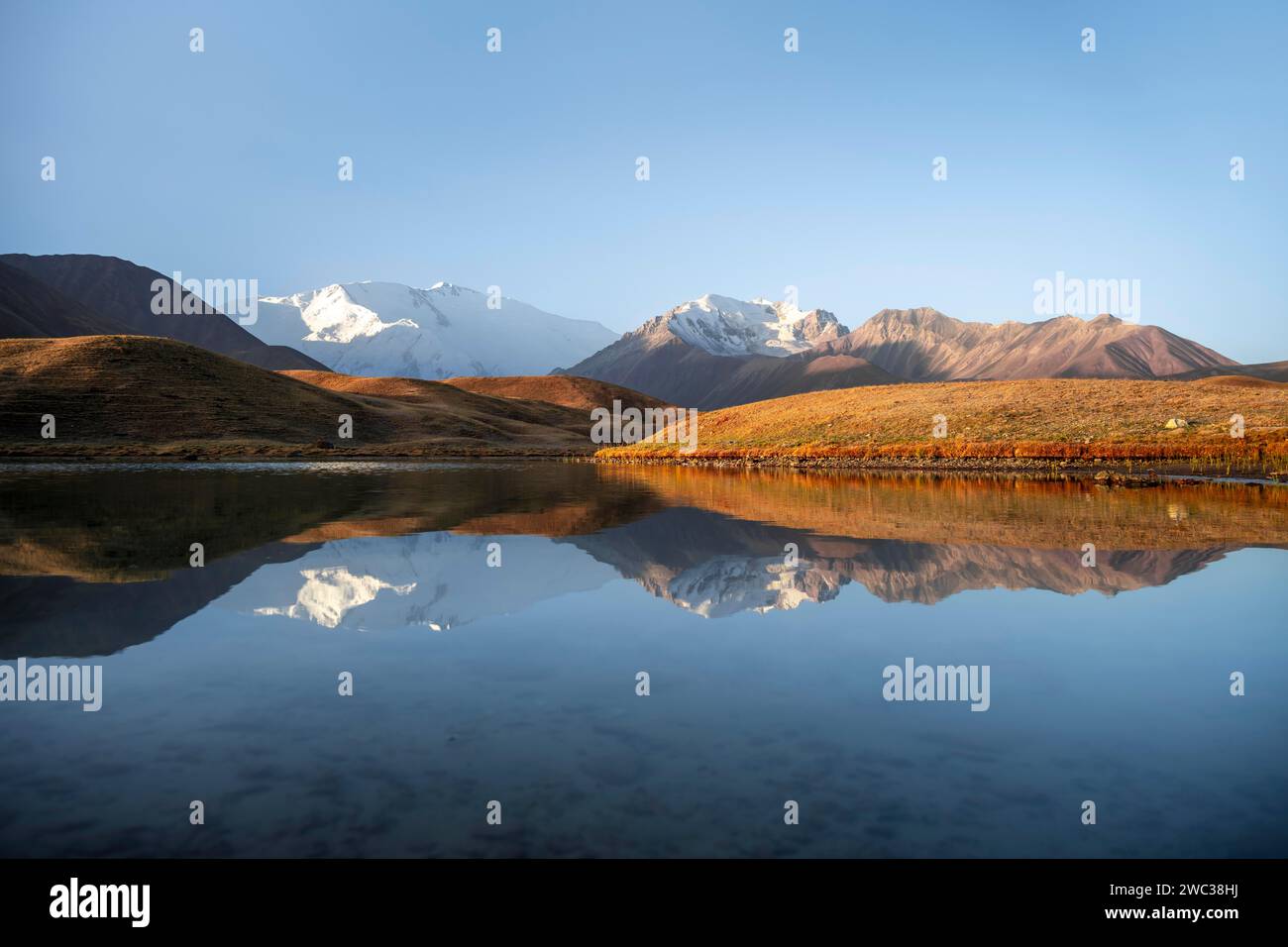 Atmosphère matinale, montagnes reflétées dans un petit lac de montagne, Pik Lenin, Trans Alay Mountains, Pamir Mountains, Osh province, Kirghizistan Banque D'Images