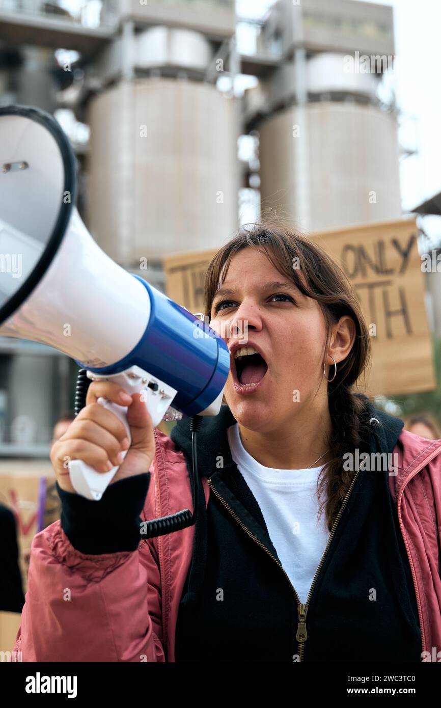 Femme en colère et rebelle parlant et protestant avec mégaphone lors d'une manifestation contre le changement climatique Banque D'Images
