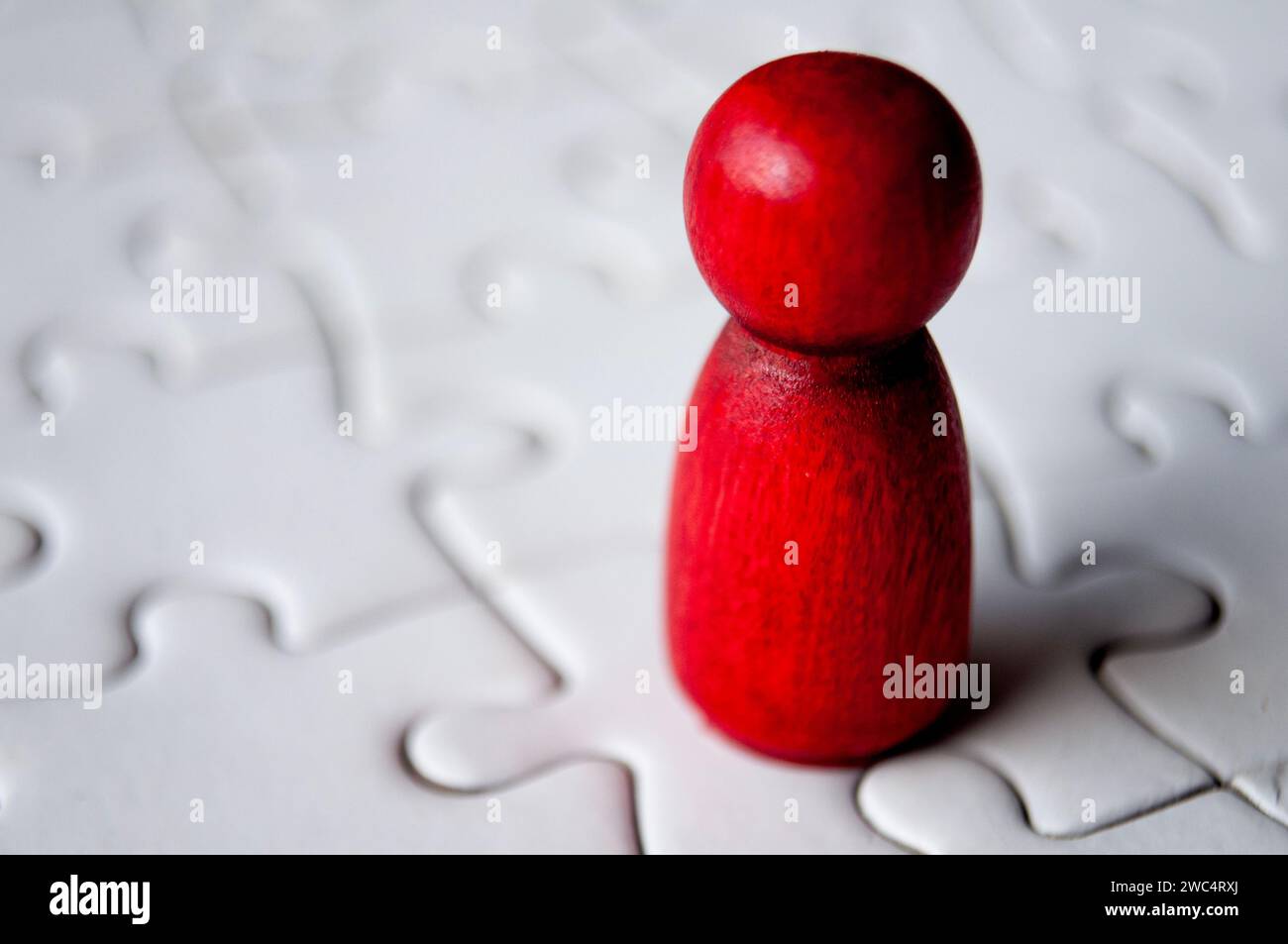 Une poupée en bois rouge unique sur puzzle. Banque D'Images