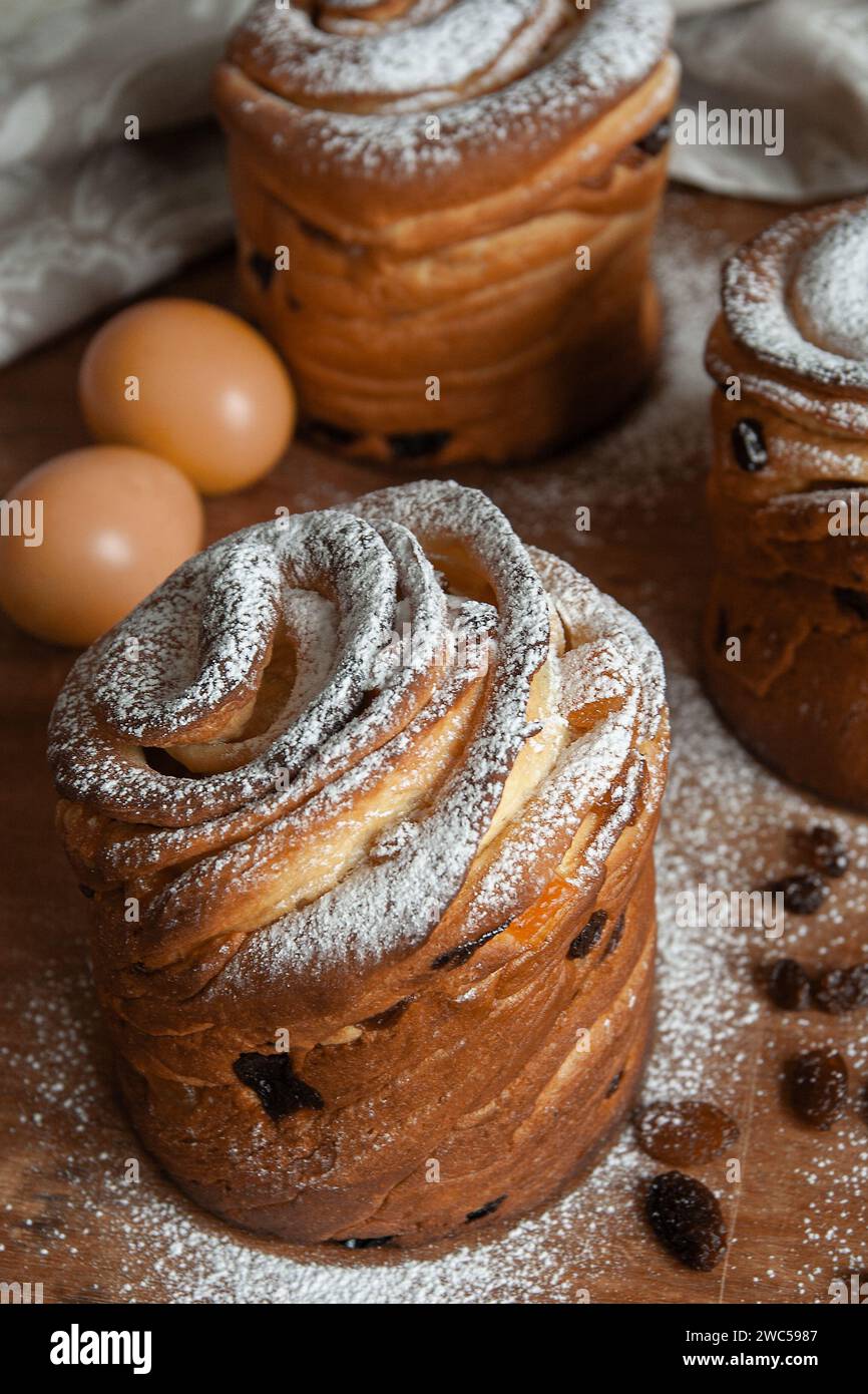 Gâteaux de Pâques kraffins aux raisins secs, fruits confits, saupoudrés de sucre en poudre. Gros plan de gâteau maison. Cruffin. Oeufs de Pâques Banque D'Images