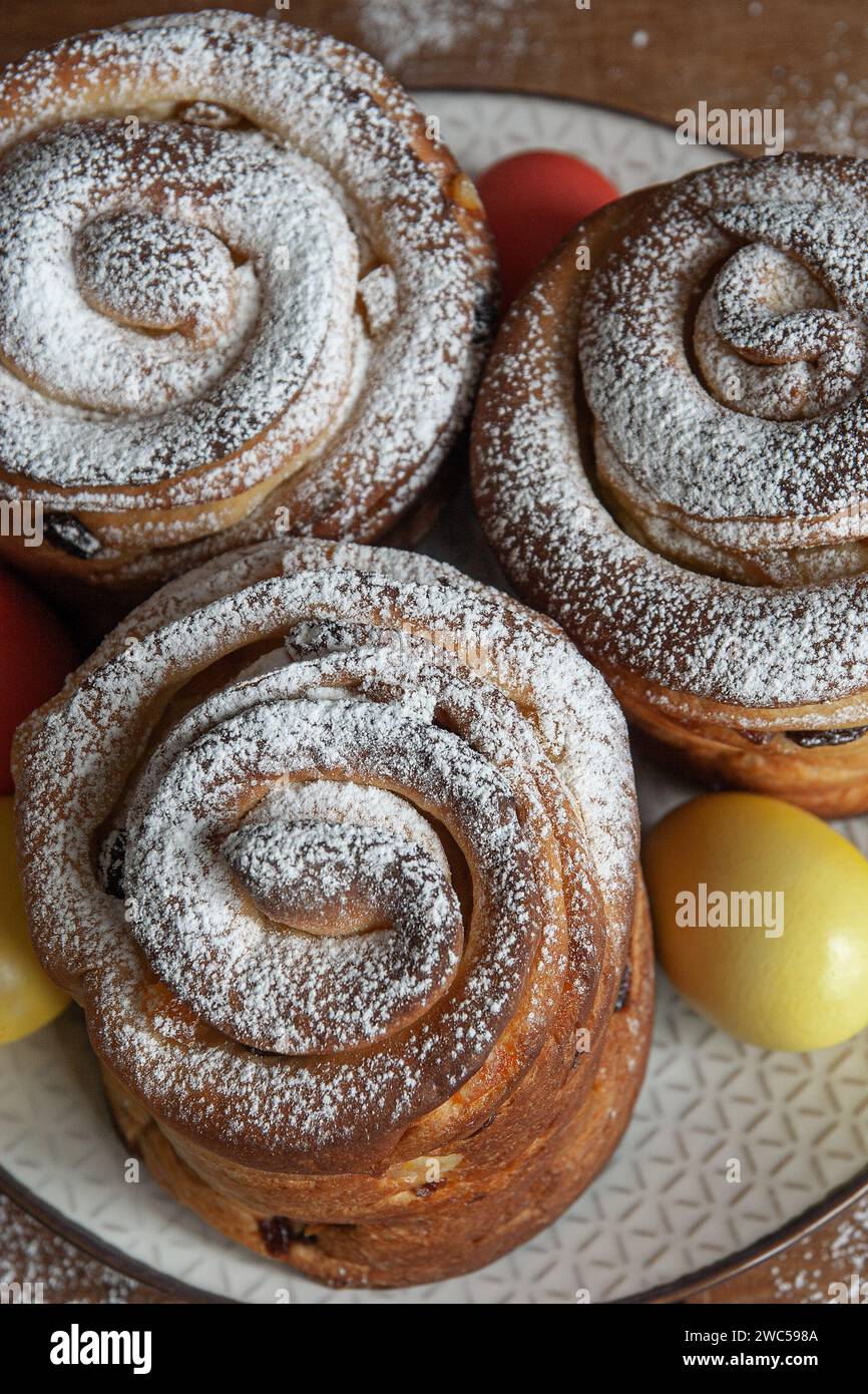 Gâteaux de Pâques kraffins aux raisins secs, fruits confits, saupoudrés de sucre en poudre. Gros plan de gâteau maison. Cruffin. Oeufs de Pâques Banque D'Images