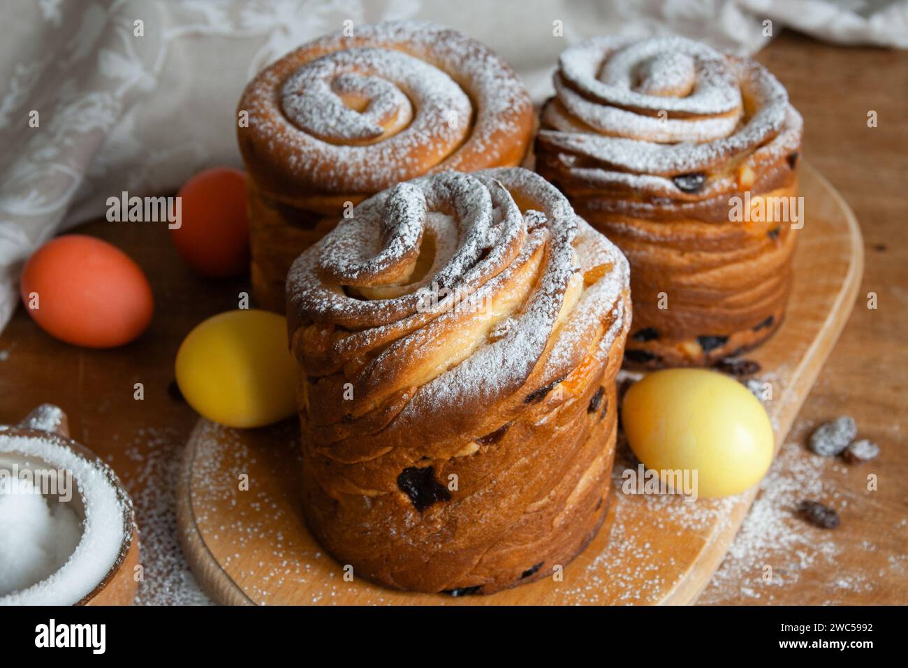 Gâteaux de Pâques kraffins aux raisins secs, fruits confits, saupoudrés de sucre en poudre. Gros plan de gâteau maison. Cruffin. Oeufs de Pâques Banque D'Images