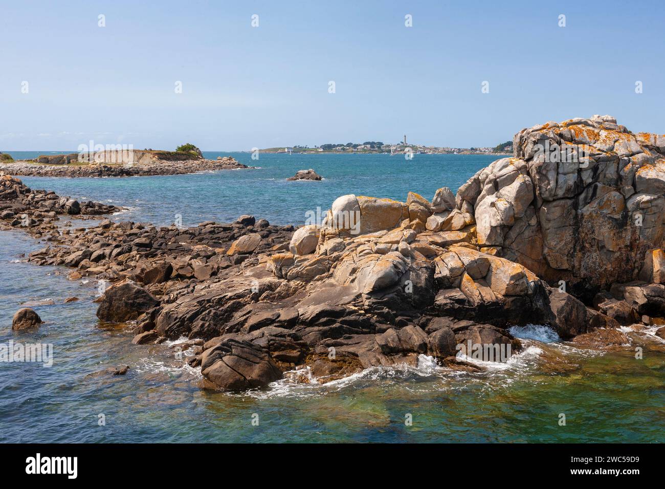 Rochers et îlots au large de Roscoff, Finistère, Bretagne, France, avec le Île de Batz au-delà Banque D'Images