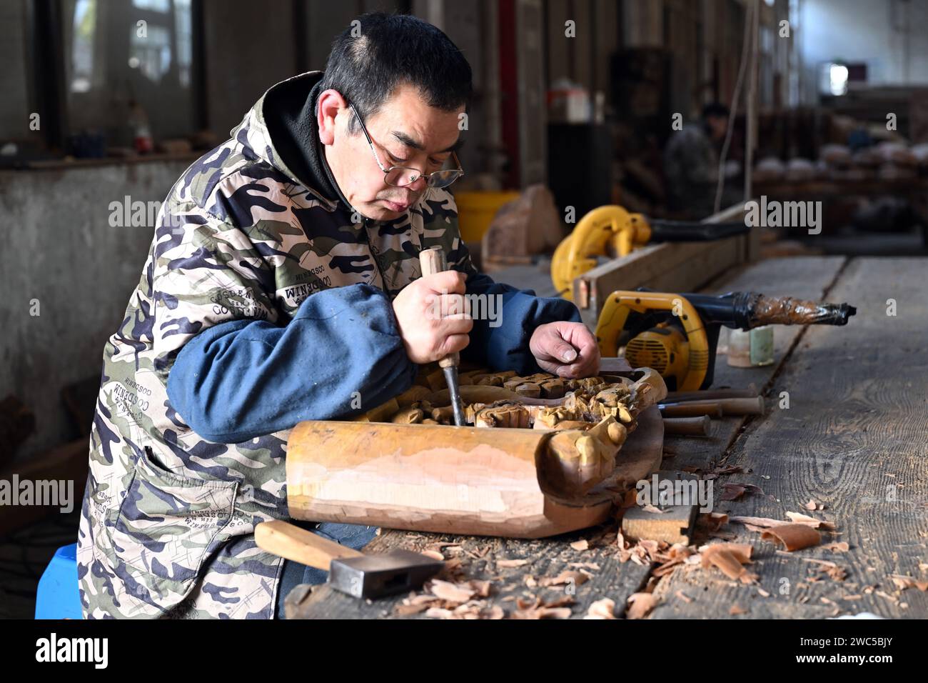 (240114) -- HUANGSHAN, 14 janv. 2024 (Xinhua) -- Un membre du personnel sculpte une composante décorative pour des bâtiments anciens de style Huizhou dans la ville de Huangshan, dans la province d'Anhui dans l'est de la Chine, le 11 janvier 2024. Huangshan a stimulé le service de construction spécialisé dans les bâtiments antiques de style Huizhou d'une manière innovante, attirant de nombreuses entreprises et talents à s'engager dans l'industrie. À ce jour, il y a 254 entreprises et plus de 14 000 artisans impliqués, qui se spécialisent dans la construction de bâtiments anciens, la rénovation de bâtiments anciens et la préparation de matériaux et de composants pour ces bâtiments. (Xinhua/Zhou Mu) Banque D'Images